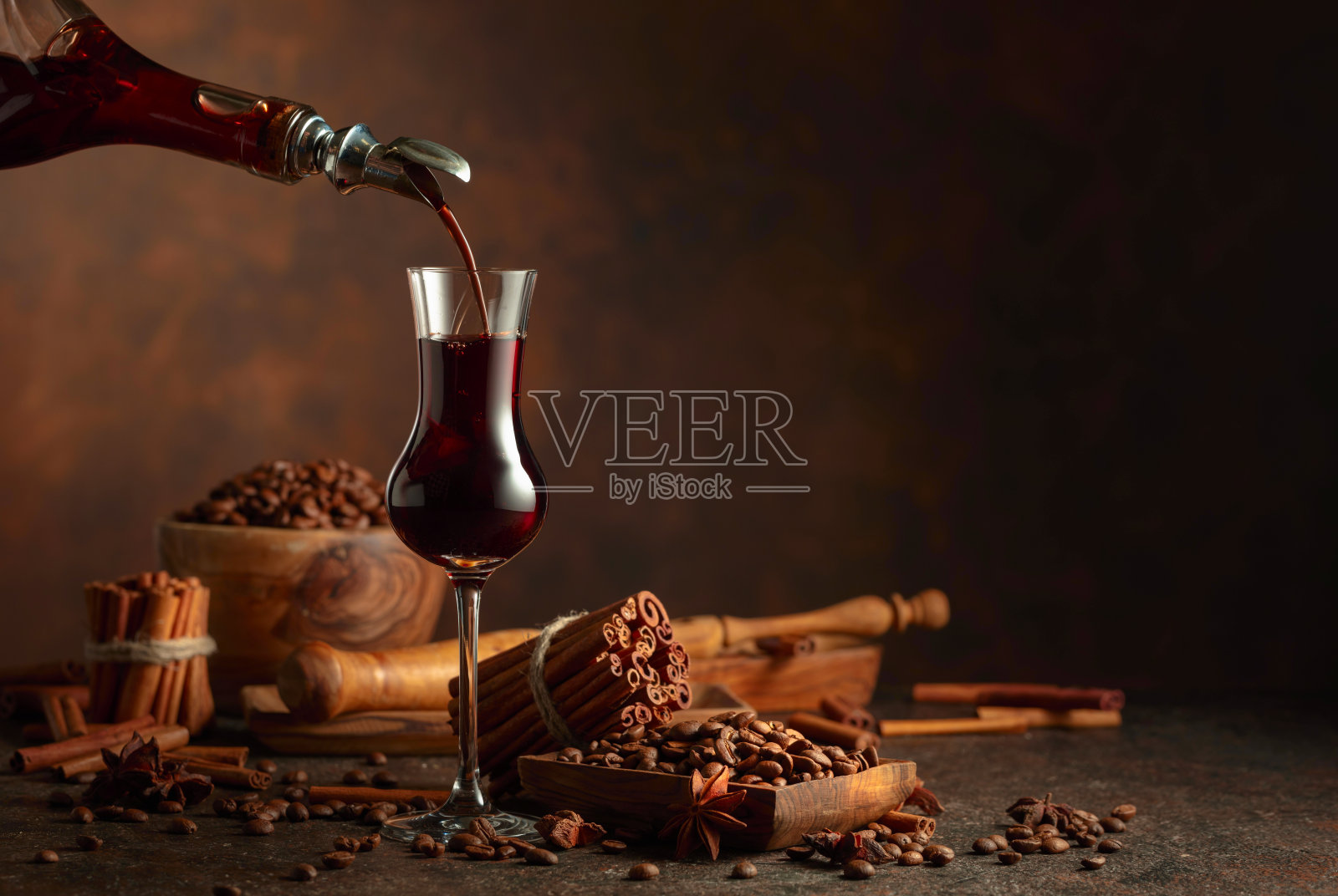 咖啡酒从瓶子倒入玻璃杯中。照片摄影图片