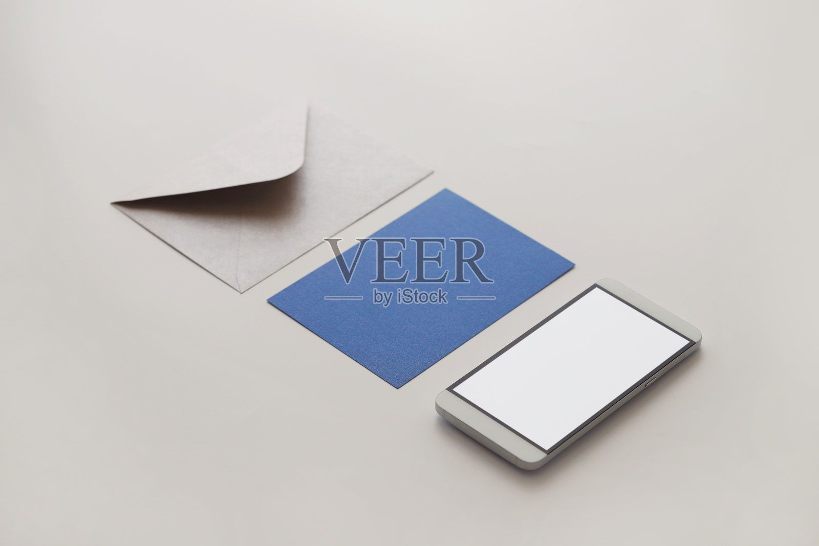 白色背景上，手机、贺卡和信封的特写镜头照片摄影图片