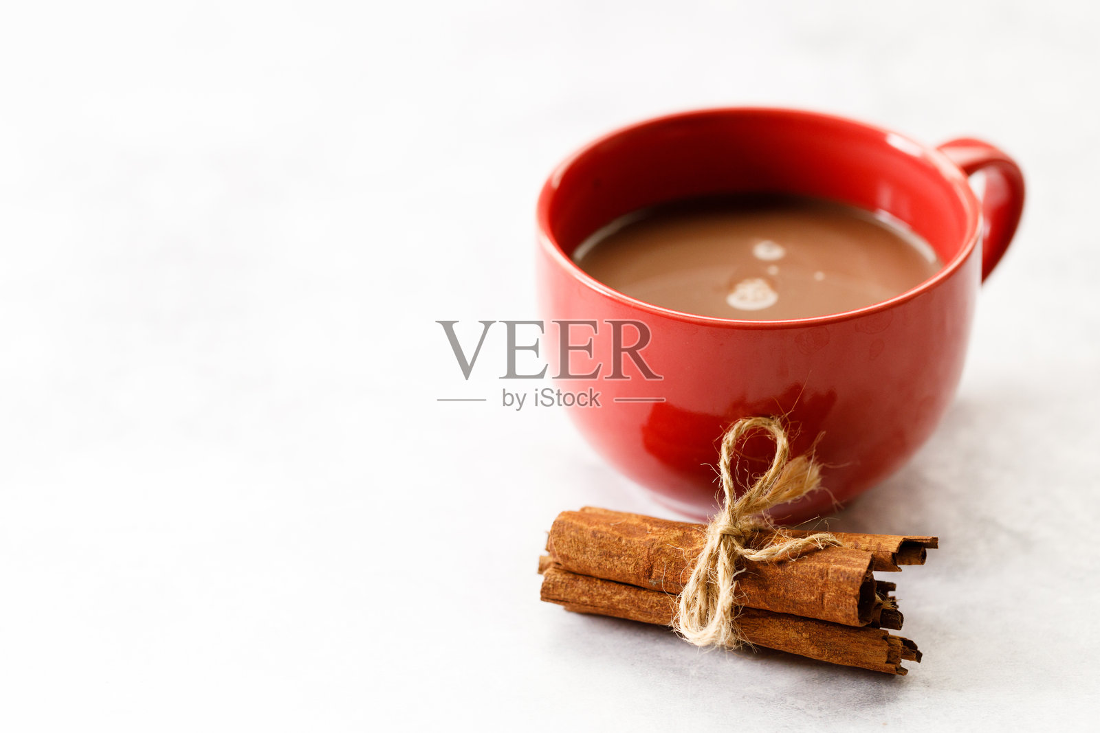 白色桌面上的美味热巧克力红杯。照片摄影图片