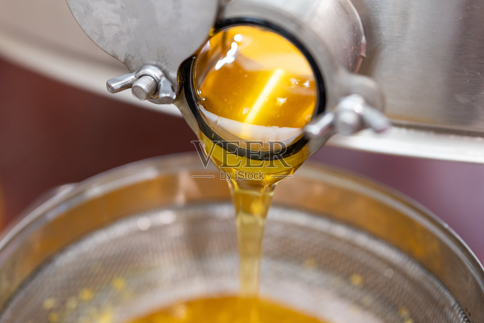 蜜蜂提取器的水龙头特写，流出刚刚收获的蜂蜜照片摄影图片