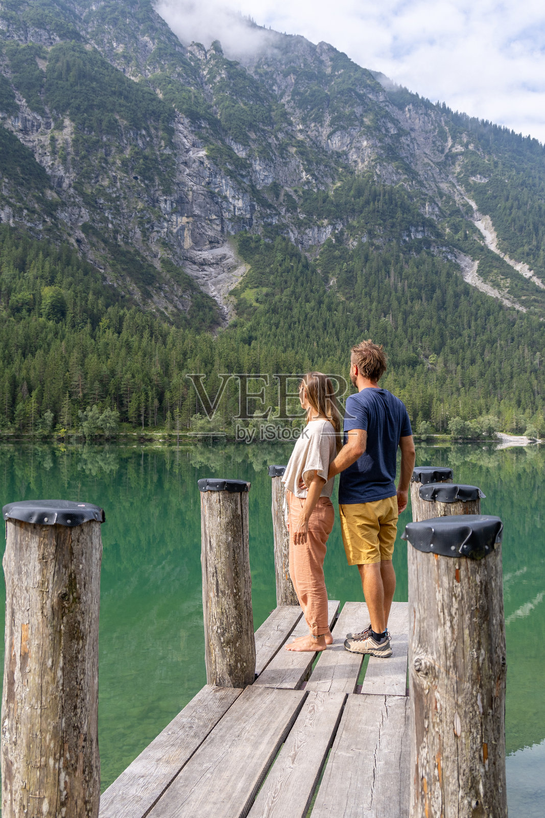 情侣在美丽的阿尔卑斯湖畔的码头上亲密互动照片摄影图片