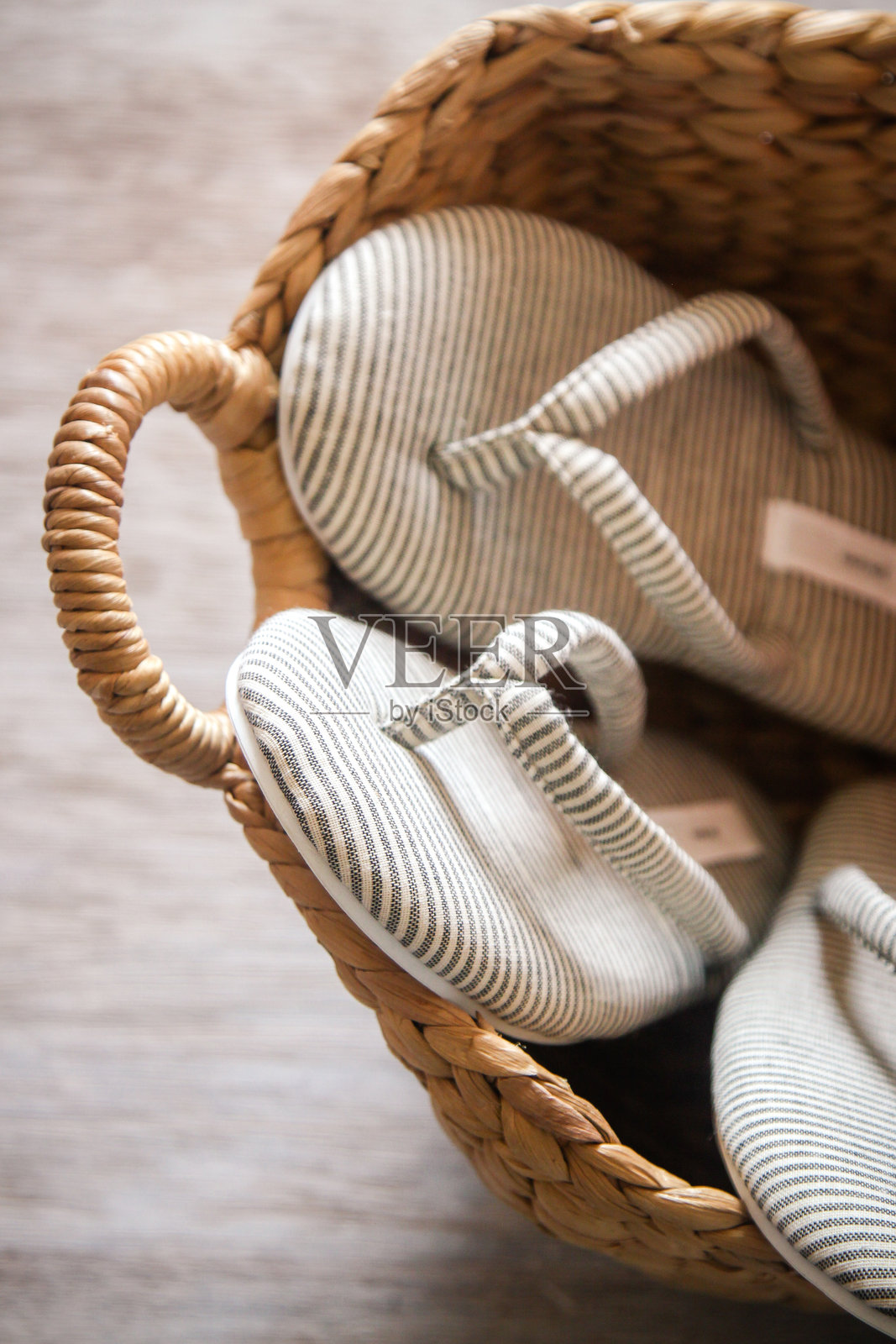 舒适的棉质家居拖鞋为客人准备，放在农舍风格的健康水疗中心的柳条篮中照片摄影图片