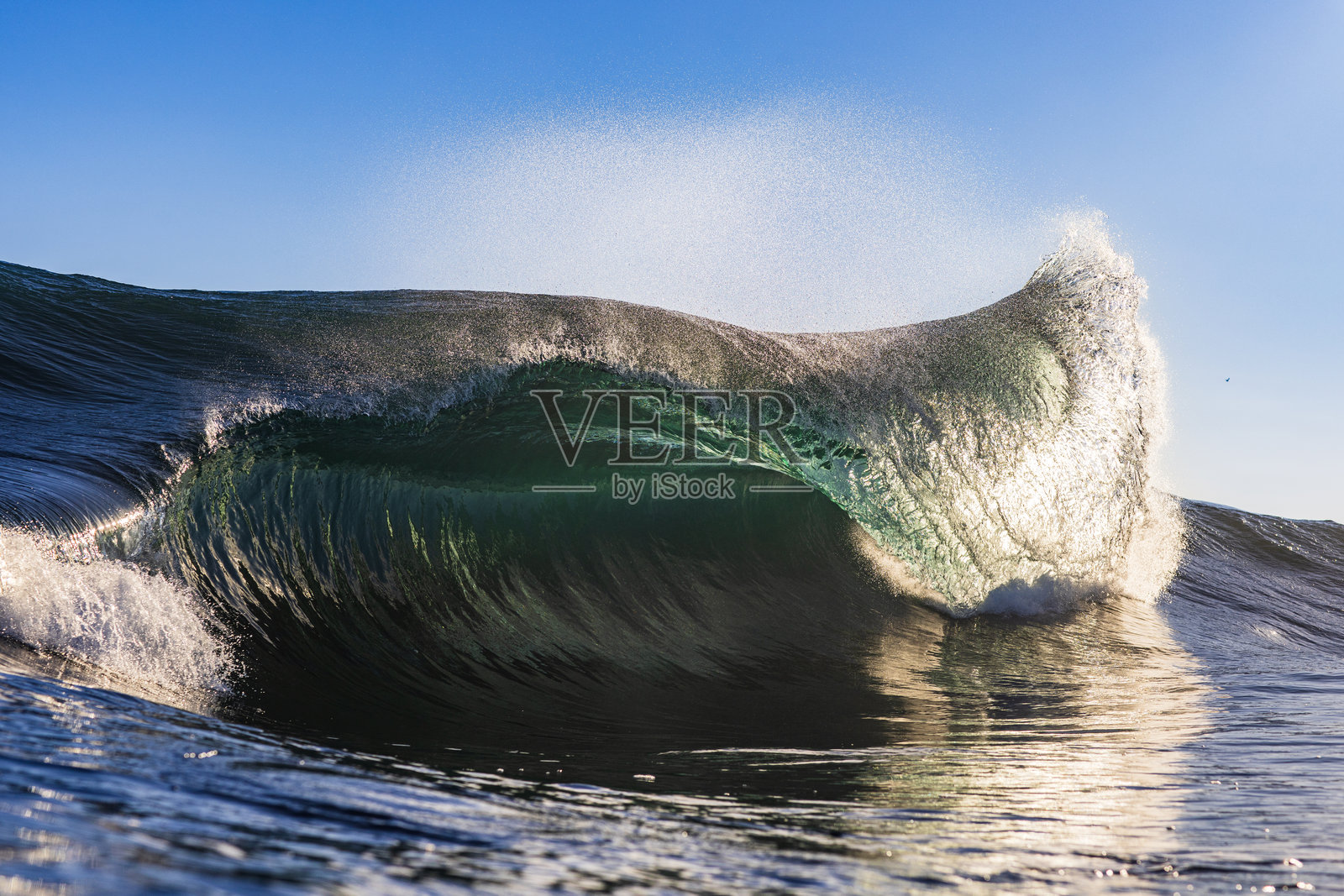 海浪在日出时分破碎，金色光芒照耀下的特写镜头照片摄影图片