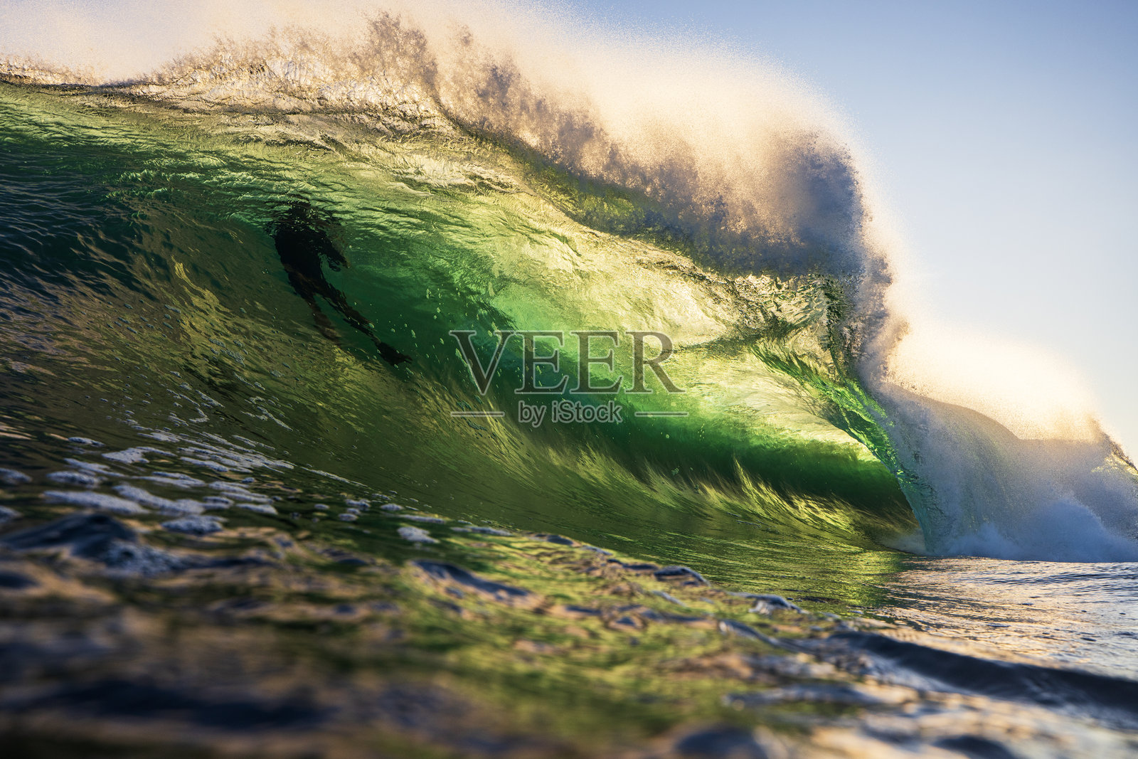 海浪在日出时分破碎，金色光芒照耀下的特写镜头照片摄影图片
