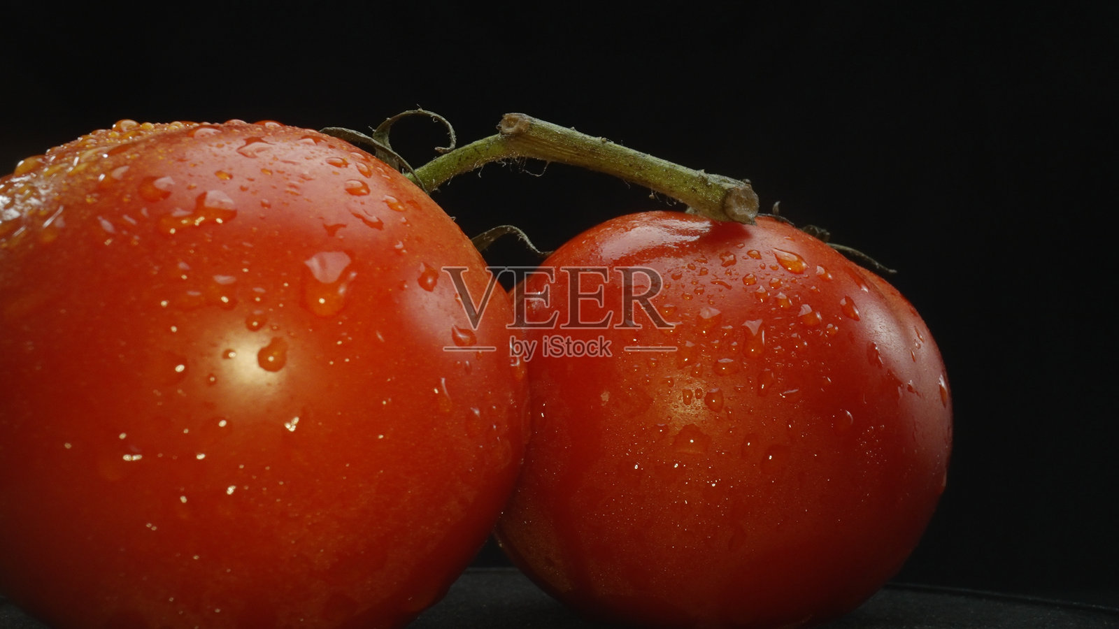 宏观摄影，番茄 nestled 在黑色背景的篮子里。可食用的。照片摄影图片