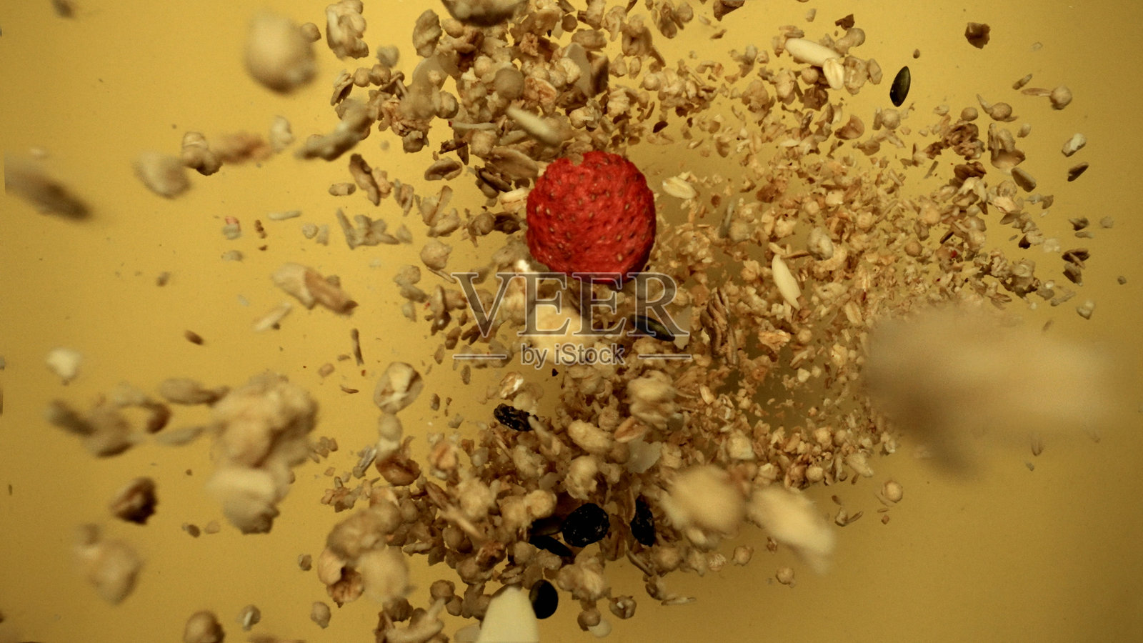 慢动作中飞翔的麦片与草莓，背景为黄色。可食用。照片摄影图片