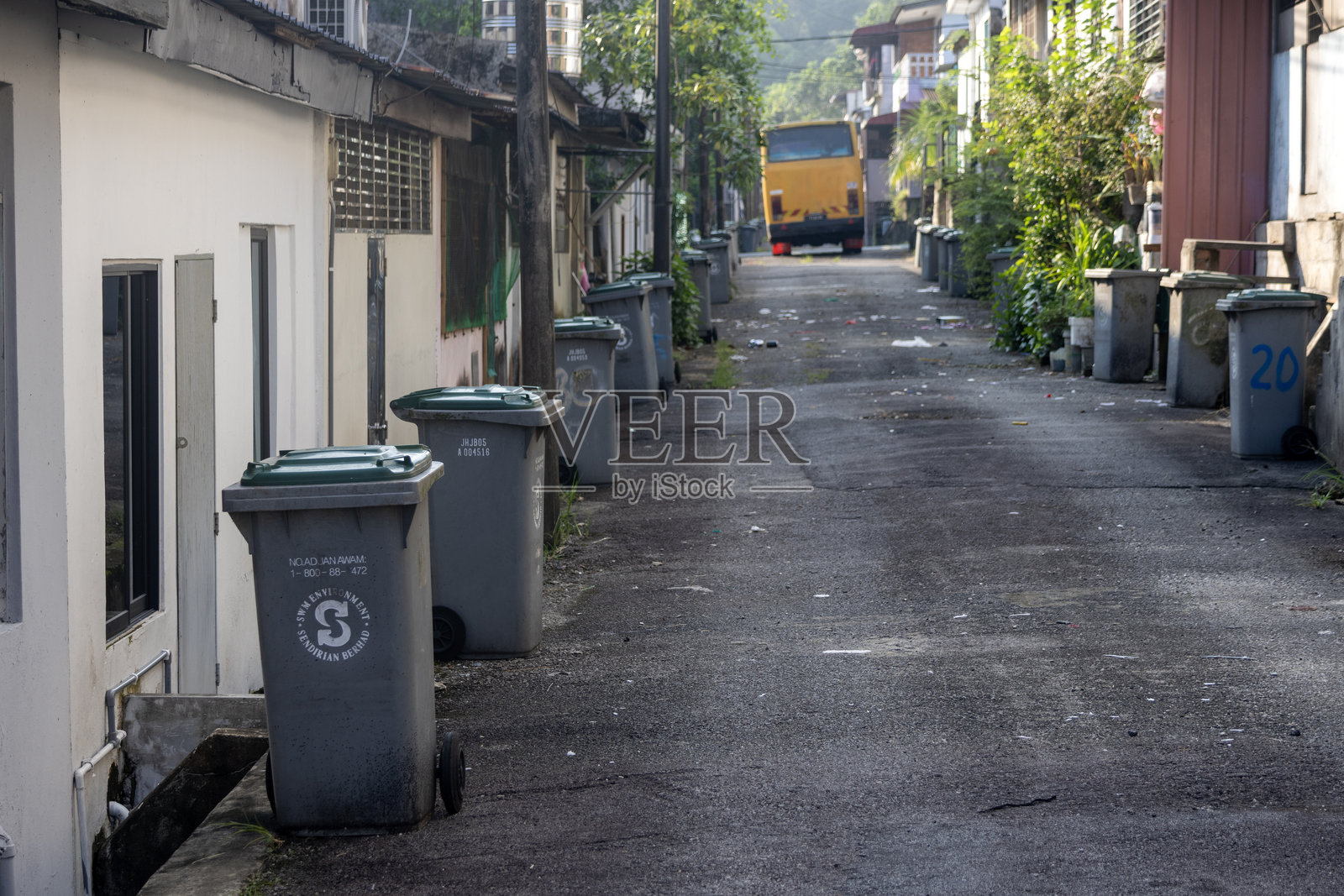 马来西亚柔佛巴鲁邻里房屋的后巷，旁边有垃圾桶照片摄影图片
