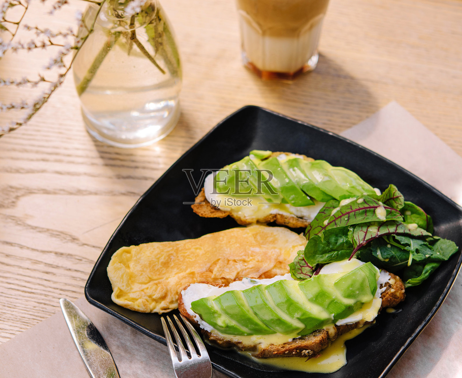 博主享受健康的早餐，搭配鳄梨吐司和拿铁咖啡照片摄影图片