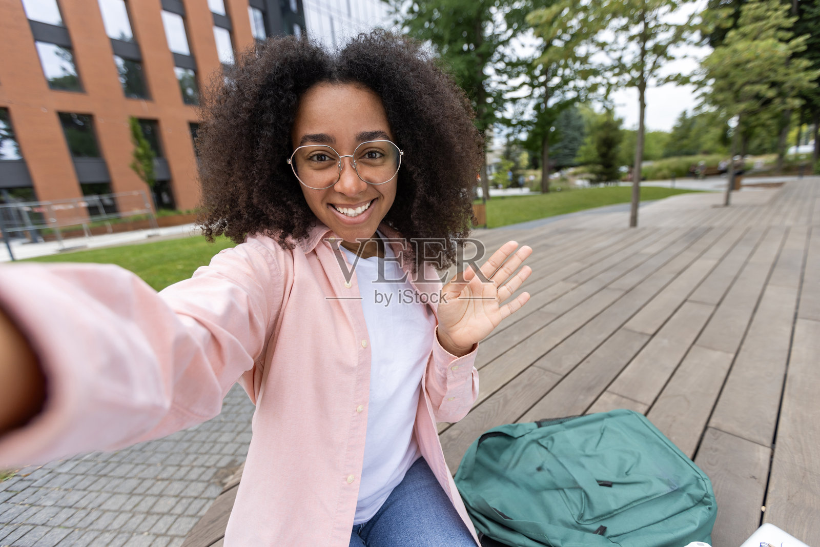 阳光明媚的一天，年轻的女学生在大学校园附近自拍照片摄影图片