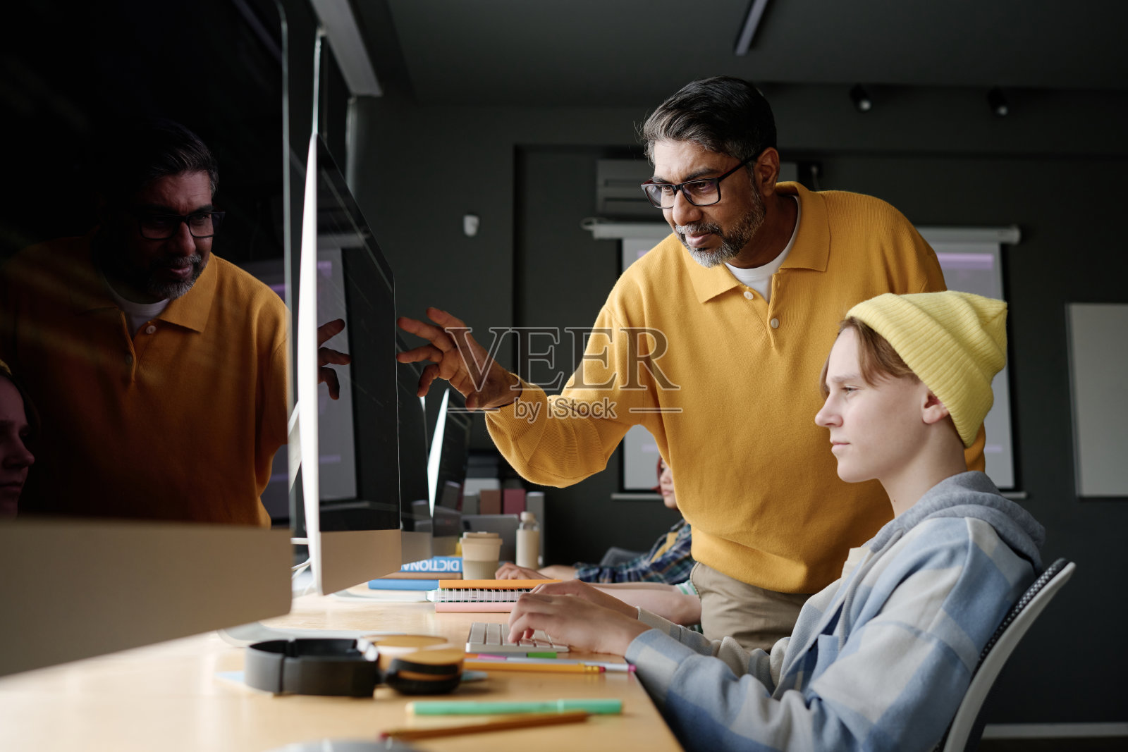 成熟的老师在课堂上与青少年学生一起工作照片摄影图片