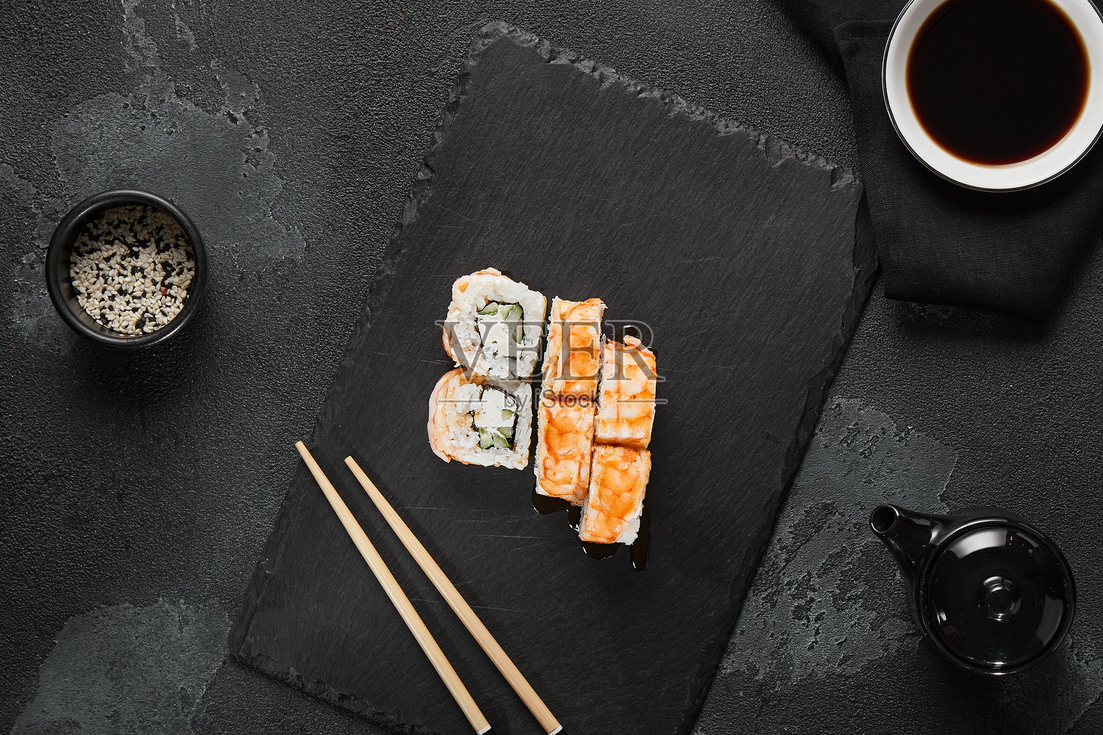 精致的虾和黄瓜卷，摆放在深色石板上，极简风格的平铺设计照片摄影图片