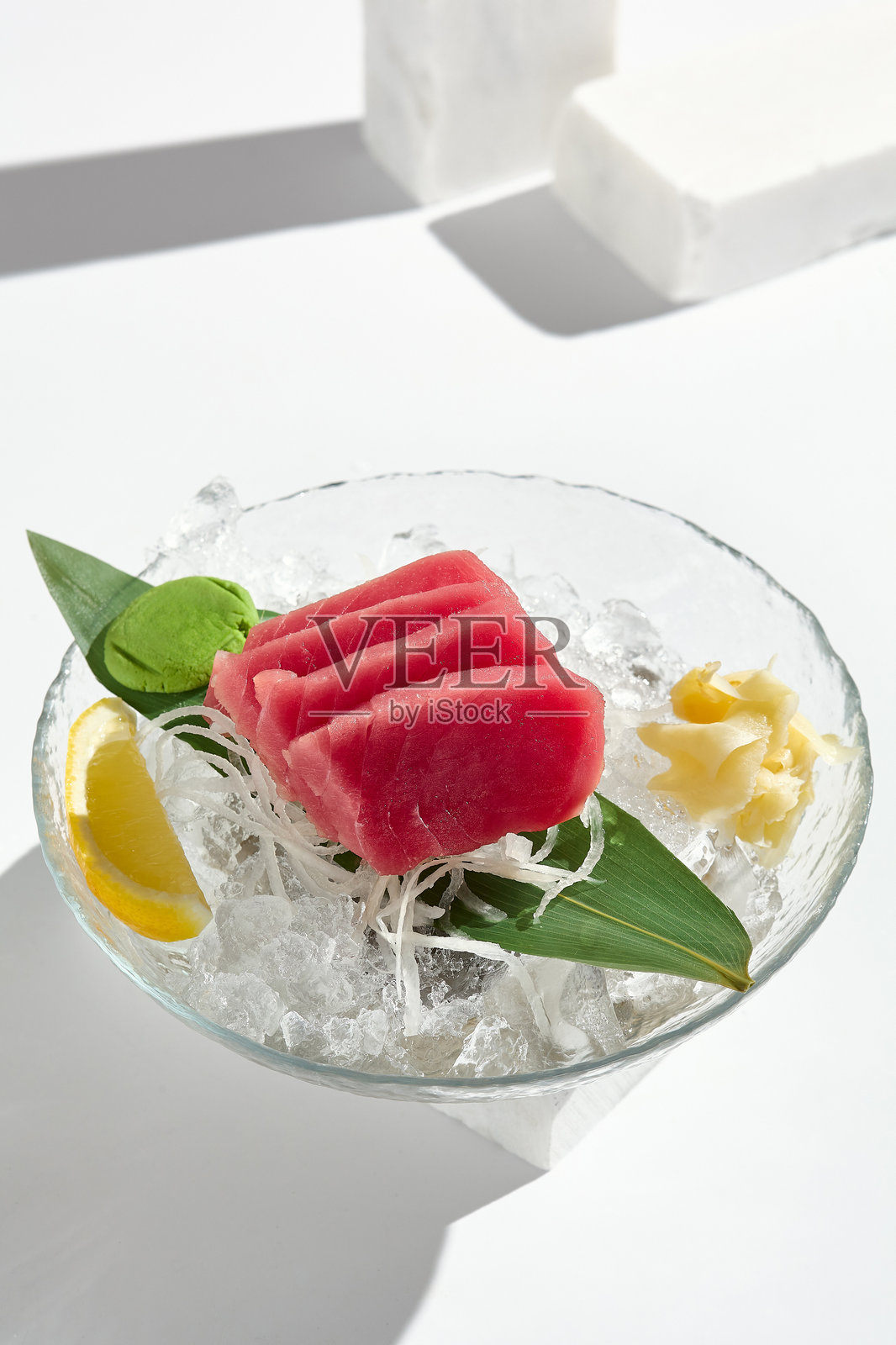 新鲜的金枪鱼刺身配冰块、柠檬和芥末 - 明亮的极简主义美食摄影照片摄影图片