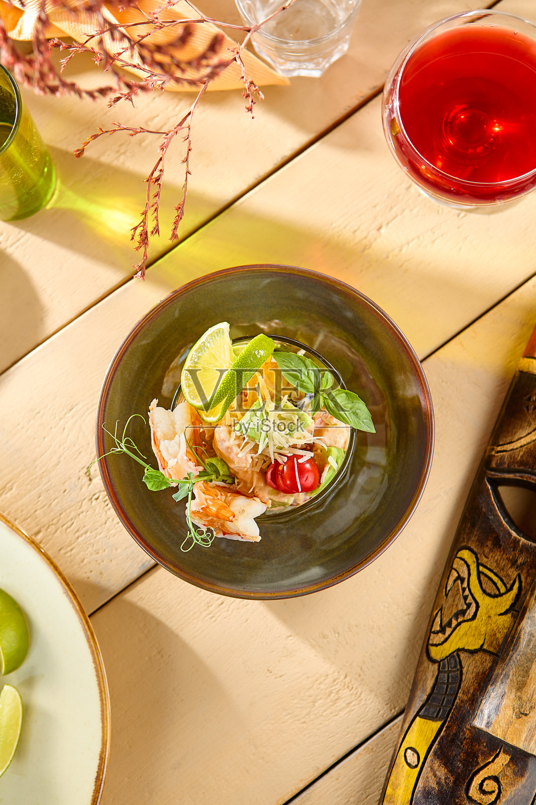 新鲜虾鸡尾酒沙拉配青柠和绿叶，置于乡村风格的环境中照片摄影图片