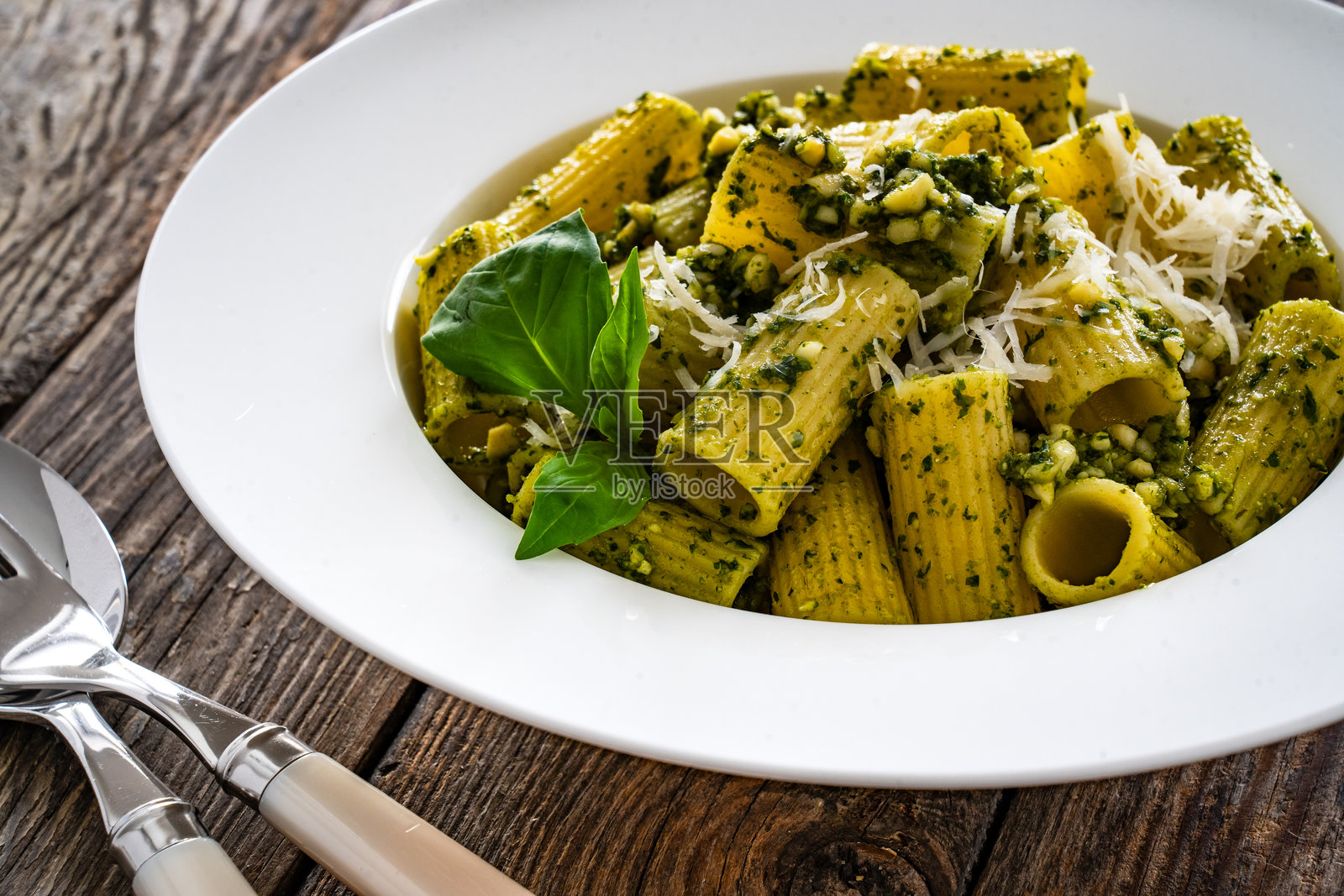 木桌上的罗勒香蒜酱意大利面照片摄影图片