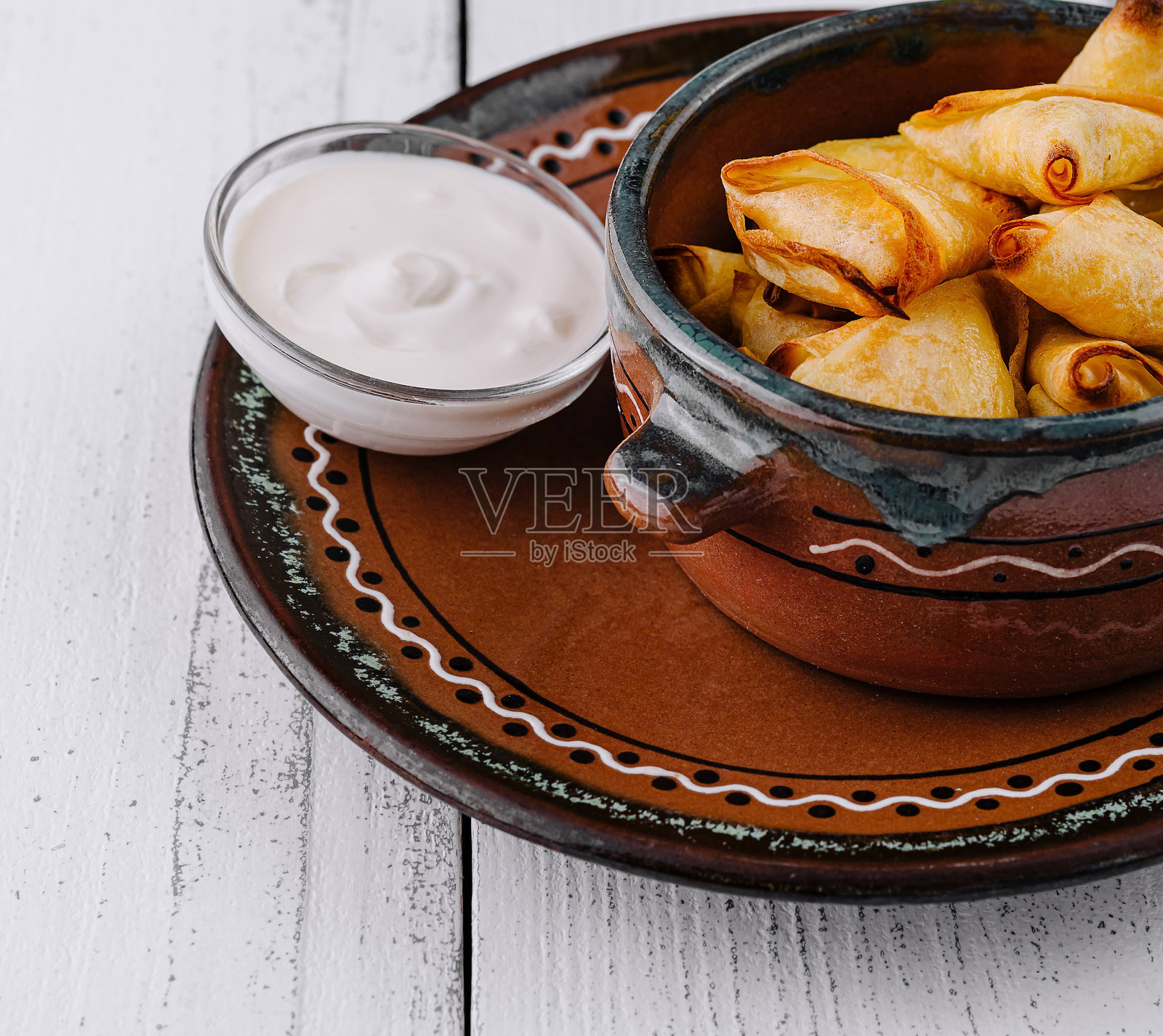 小烤饼放在白色木桌上的陶瓷碗里照片摄影图片