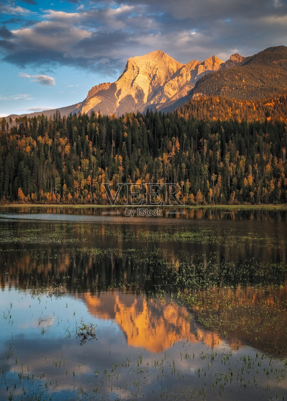 加拿大落基山脉在日落时分倒映在宁静的湖面上照片摄影图片