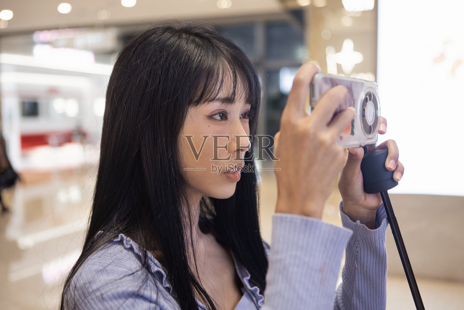 一位亚洲女性在购物中心用手机拍照照片摄影图片