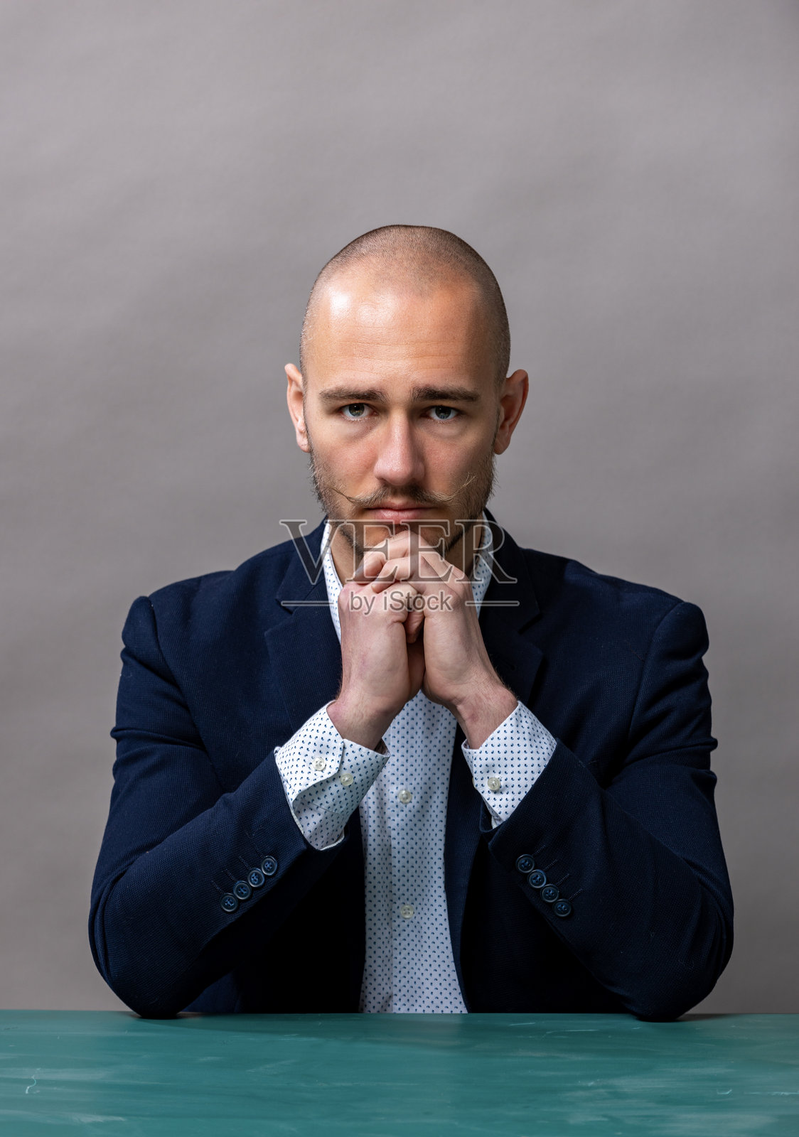 一名男子坐在桌子旁的肖像。照片摄影图片