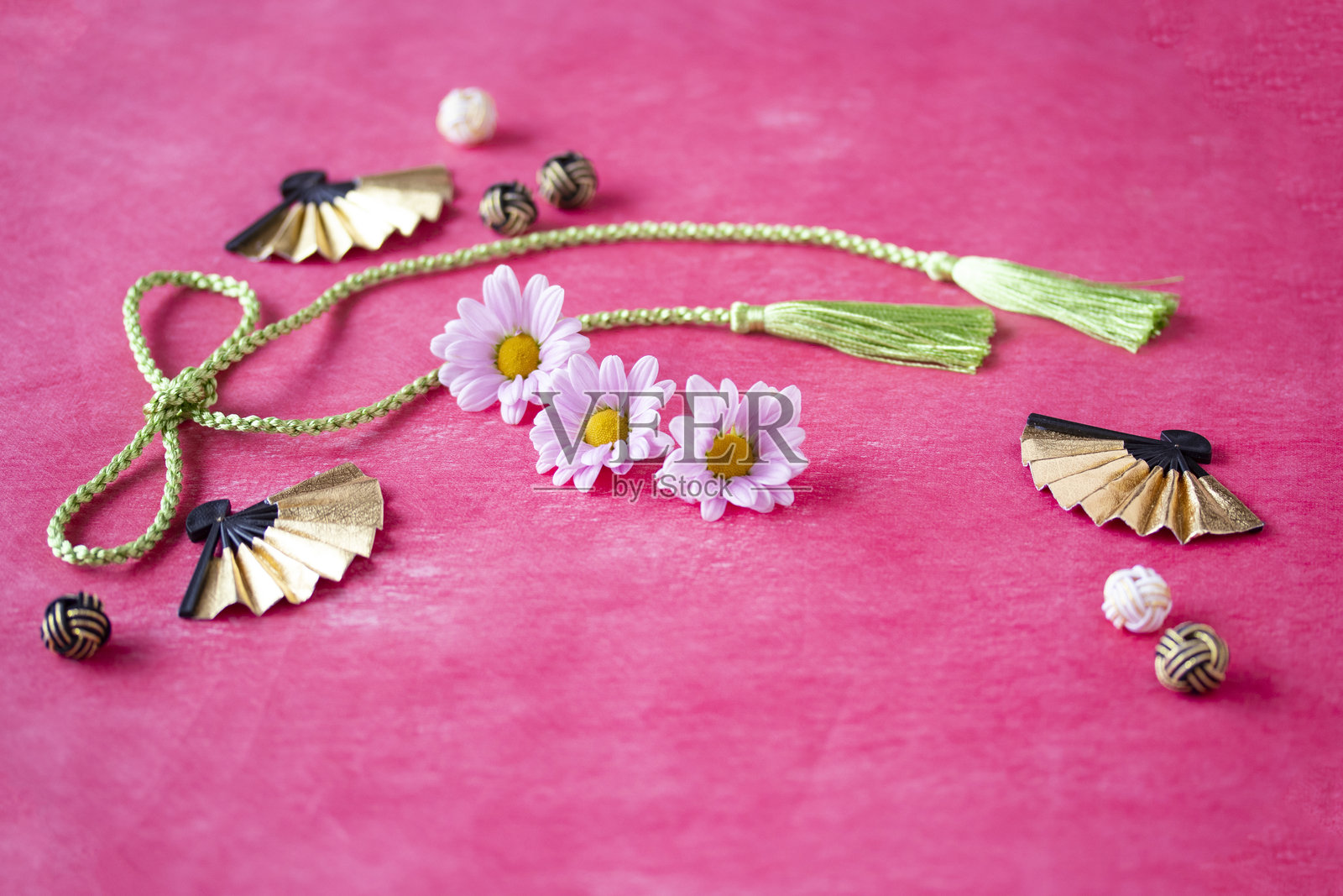 日本新年图像。/  菊花、扇子、水引和粉色日本纸上的流苏。照片摄影图片