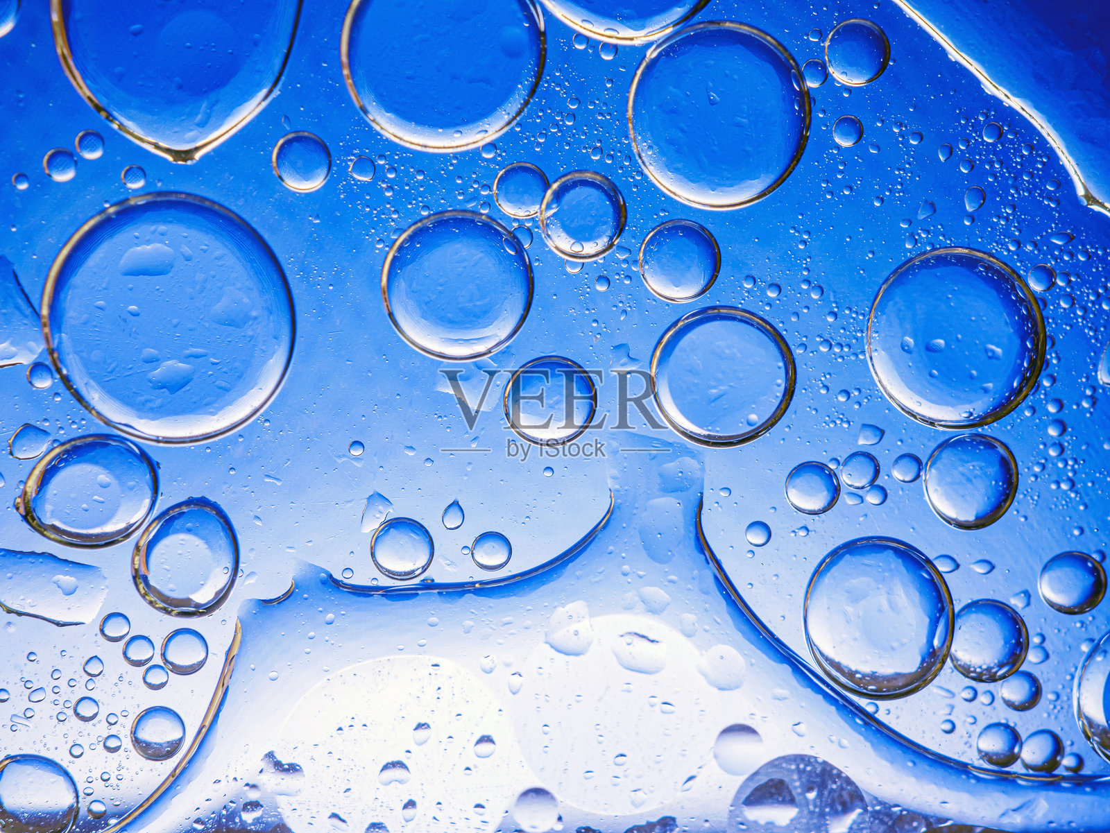 蓝色背景上的气泡。蓝色背景下海绵中的抽象氧气泡水。蓝色圆形水泡。照片摄影图片