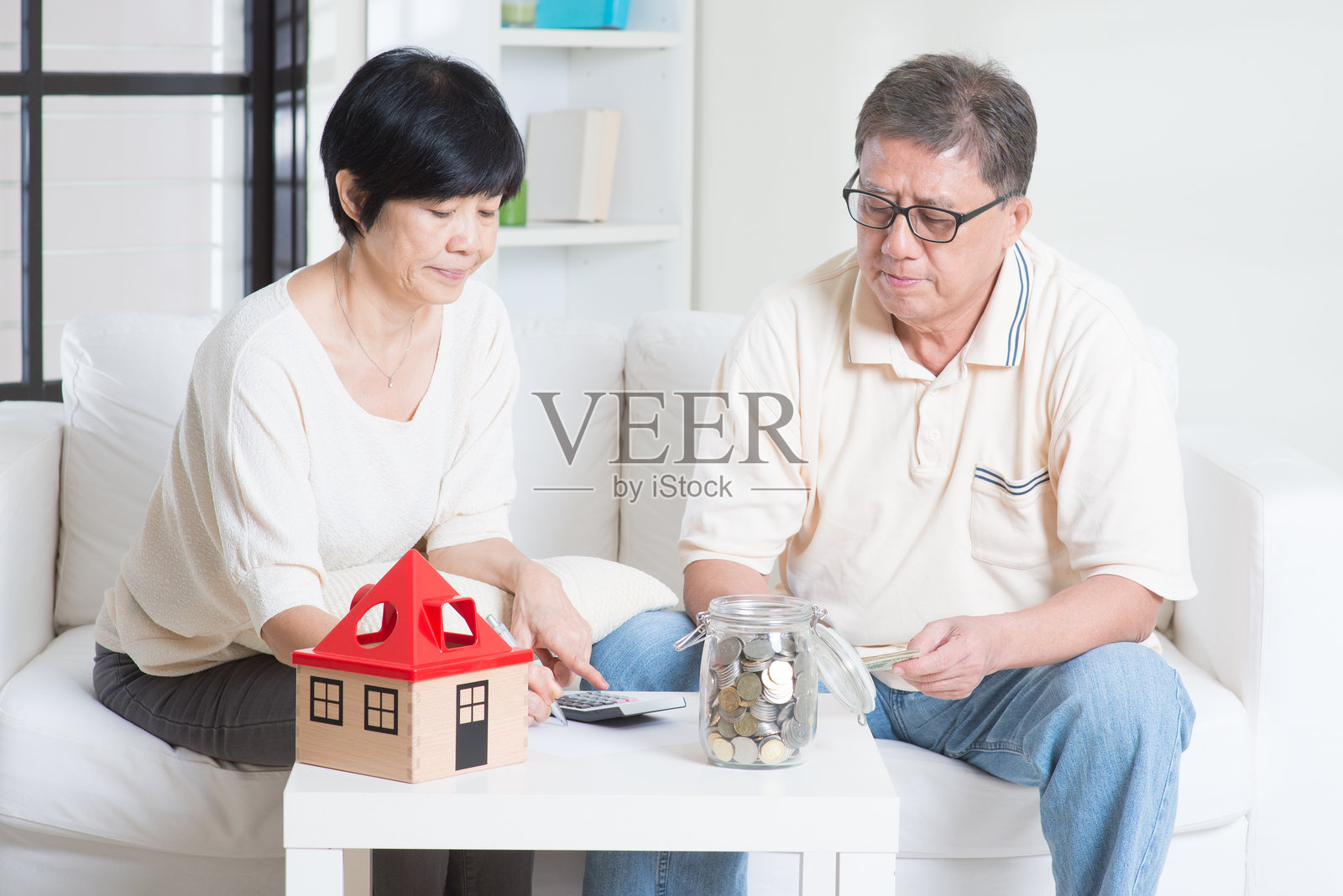 一对情侣坐在家里的沙发上数钱照片摄影图片