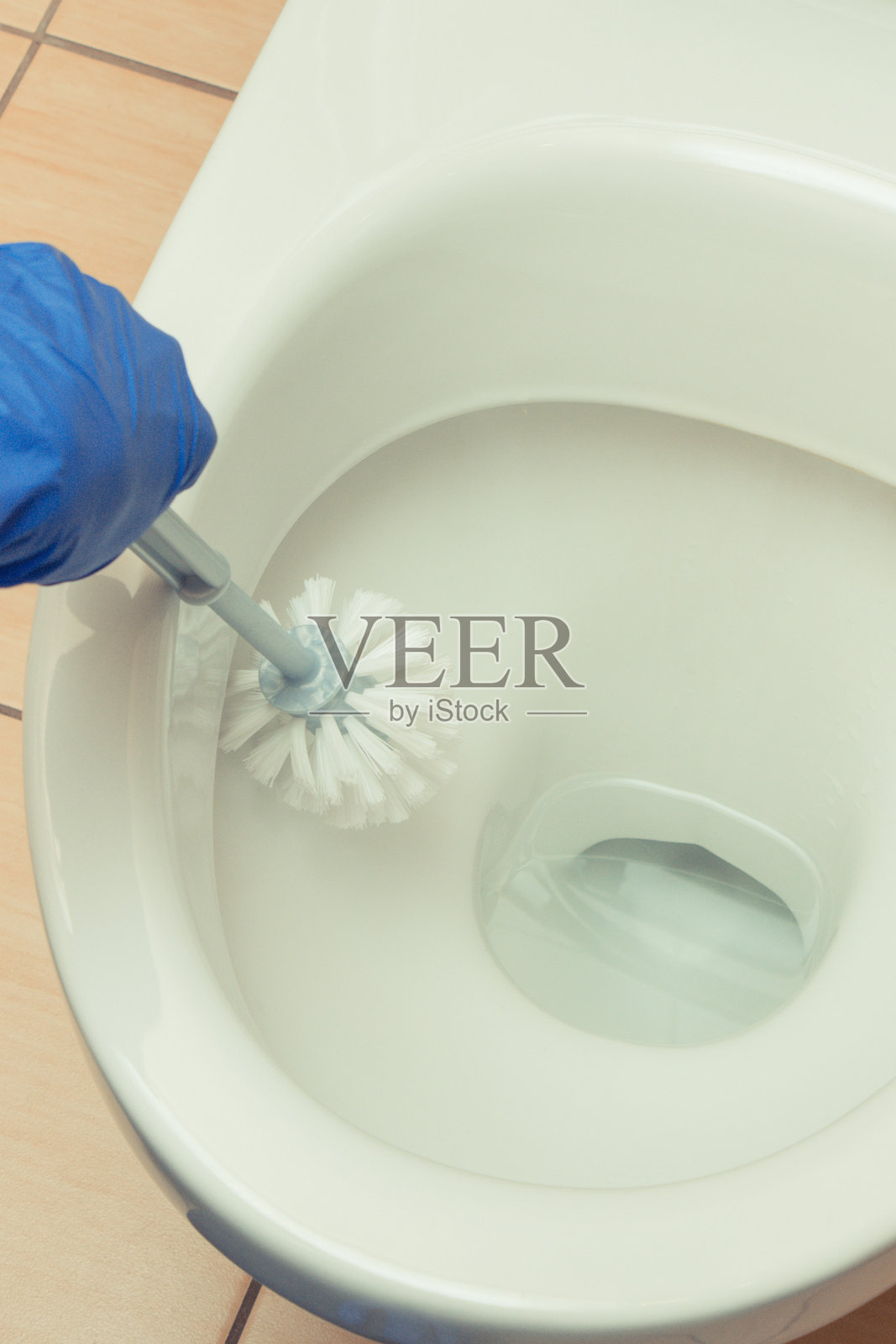 清洁工用刷子清洁厕所的手。家庭清洁工作照片摄影图片