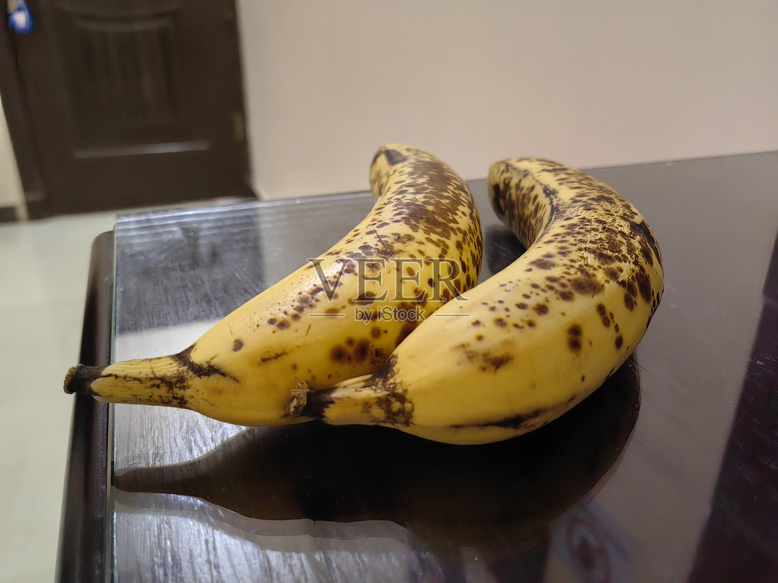 两根几乎腐烂的香蕉，表皮上有黑点。照片摄影图片