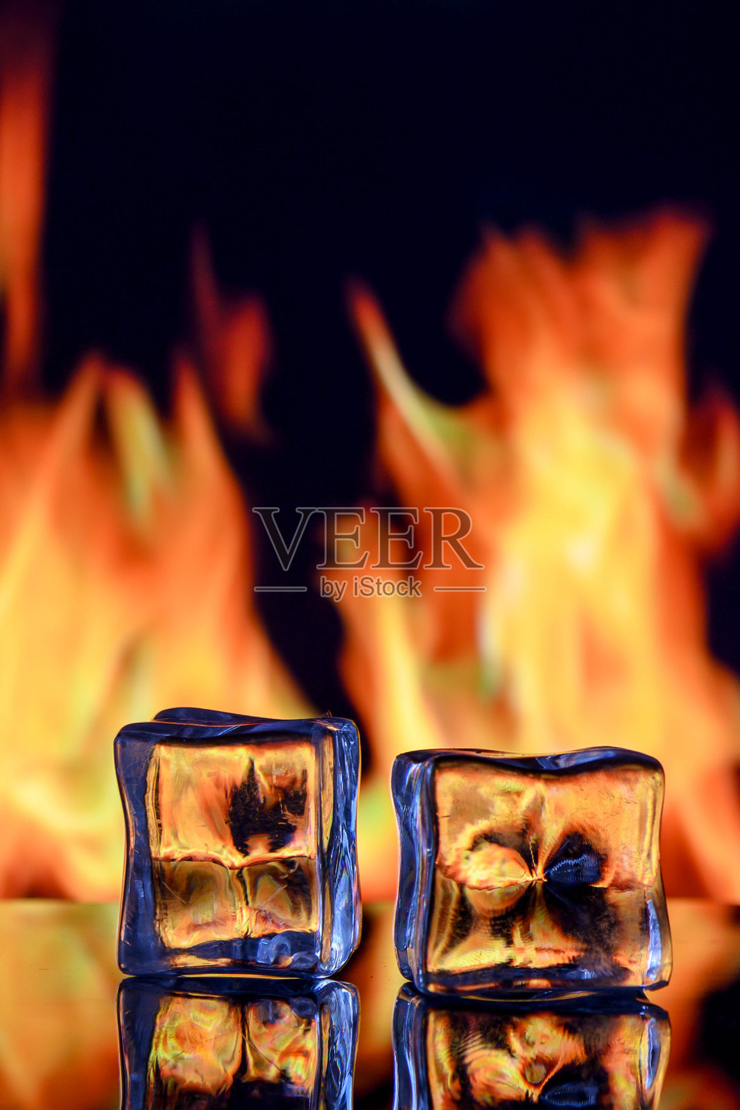 象征火与冰对比的概念摄影：一个被火焰吞噬的冰块。照片摄影图片