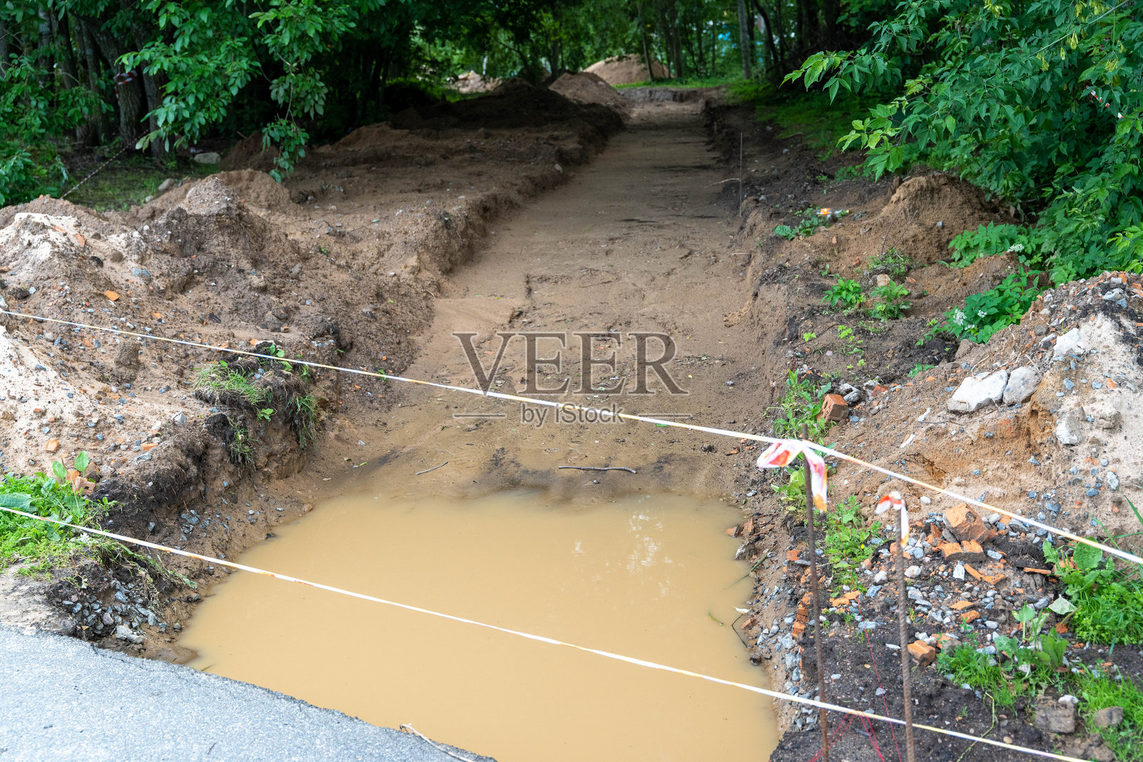 在雨后收集水的道路挖掘工作照片摄影图片