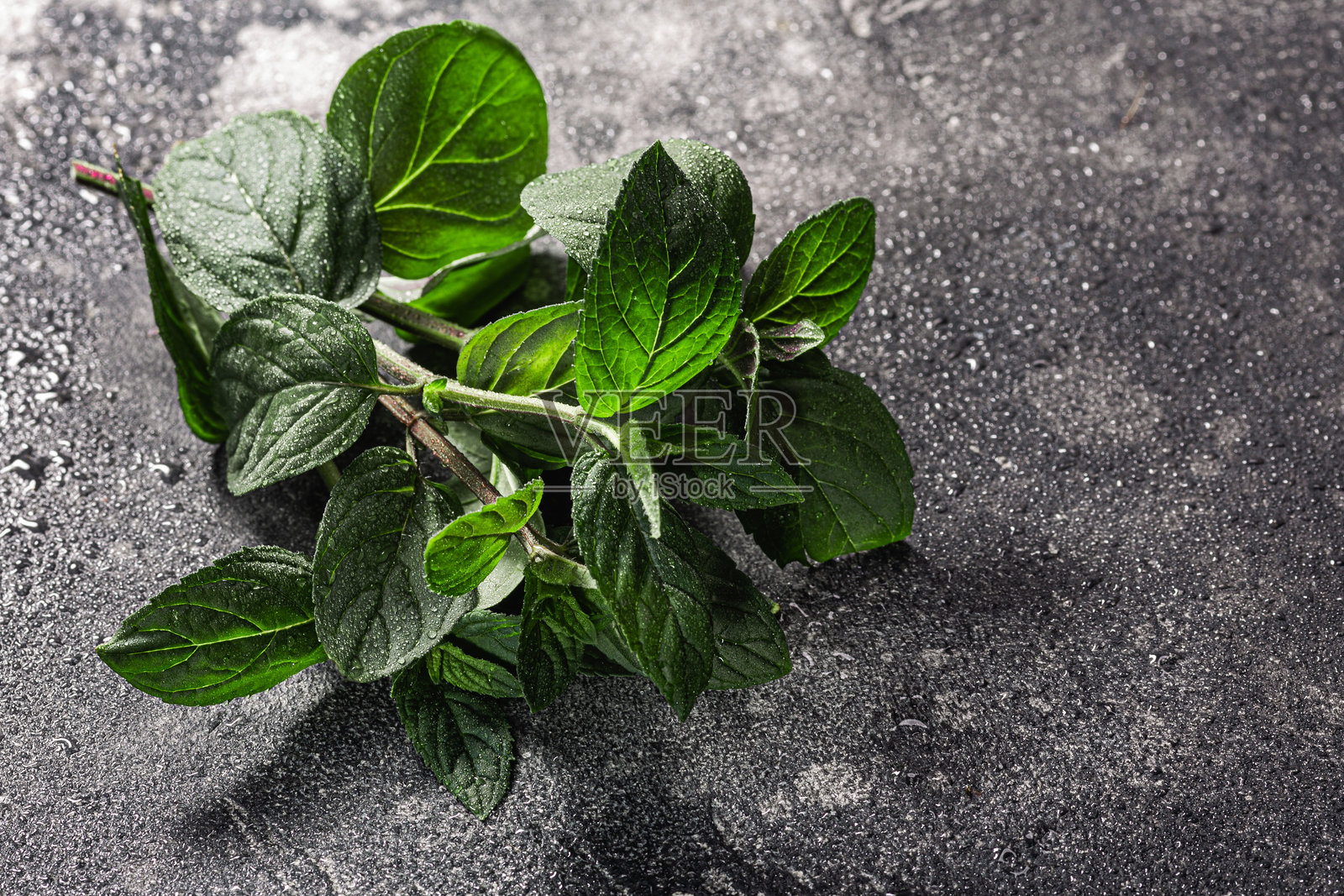 薄荷叶置于深色纹理背景上，俯视图，留白空间。薄荷草照片摄影图片