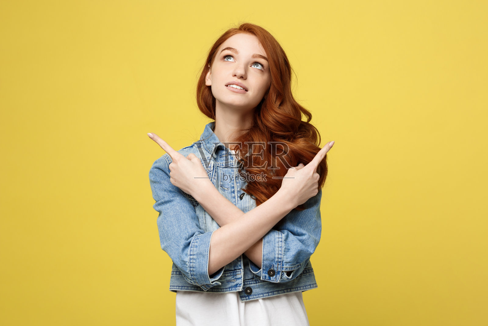 年轻女性站在黄色背景前照片摄影图片