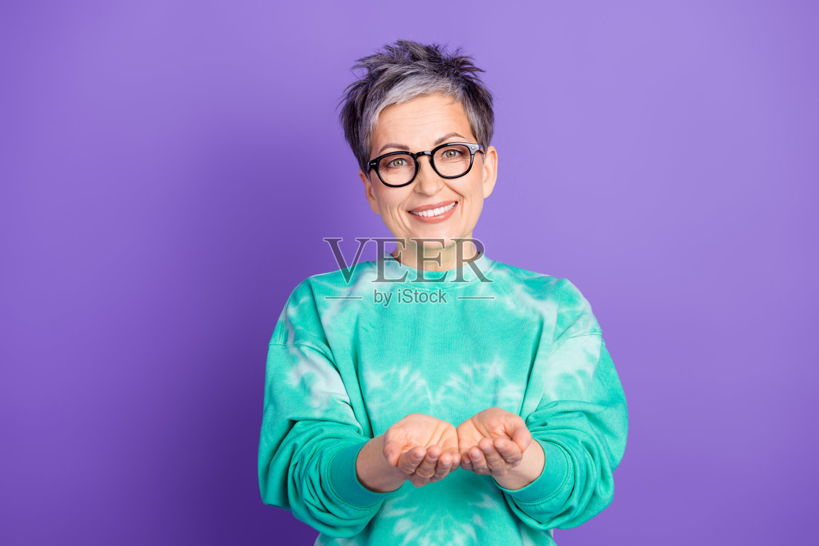 穿着时尚绿色服装的美丽退休女性在紫色背景前拍摄的空白空间肖像照照片摄影图片