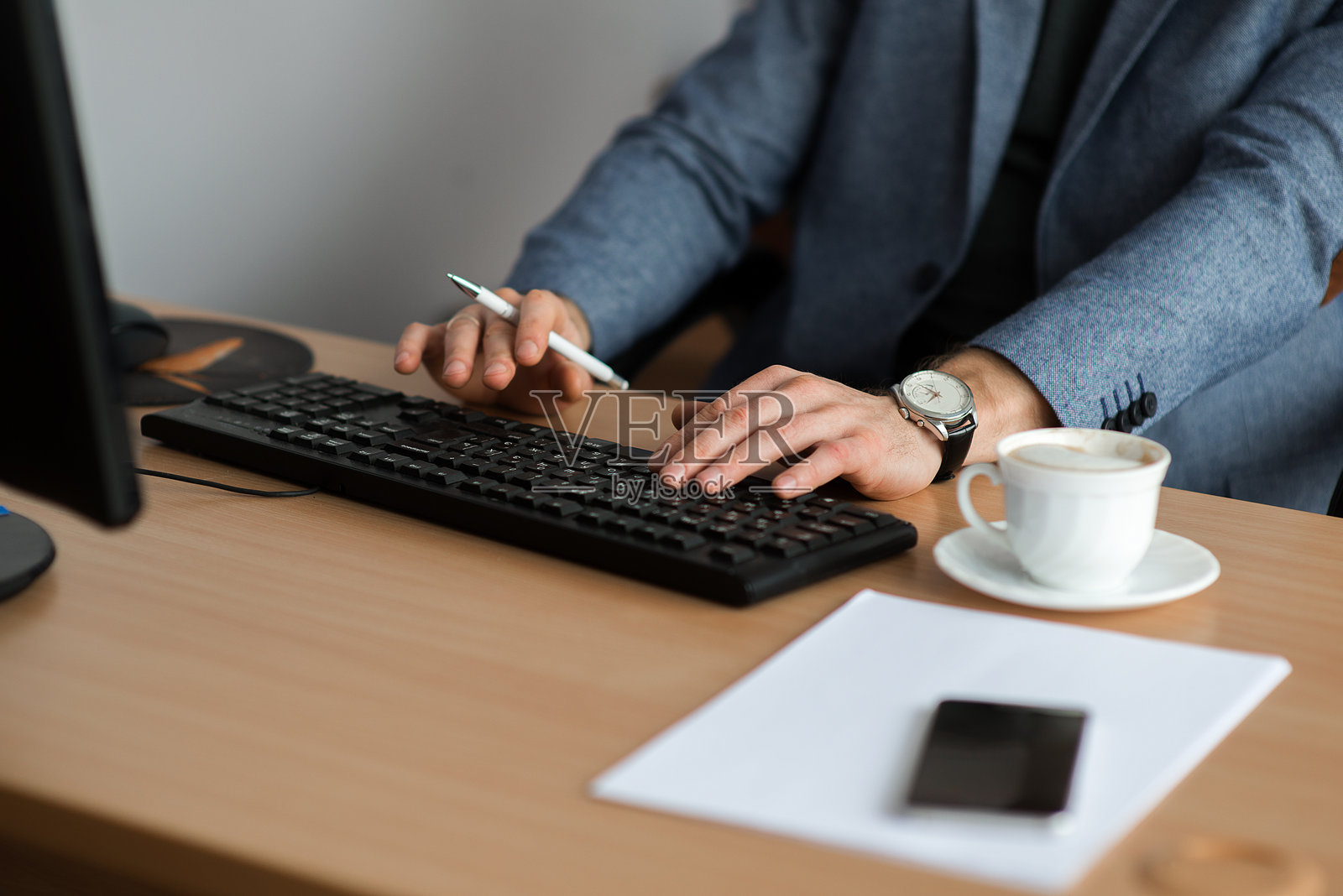 商人坐在桌子上使用台式电脑照片摄影图片