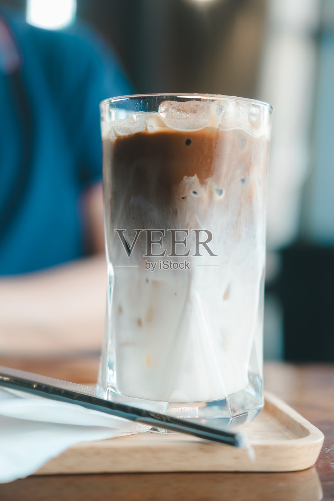 冷摩卡咖啡在玻璃杯中。新鲜牛奶和咖啡的美丽纹理和层次。照片摄影图片