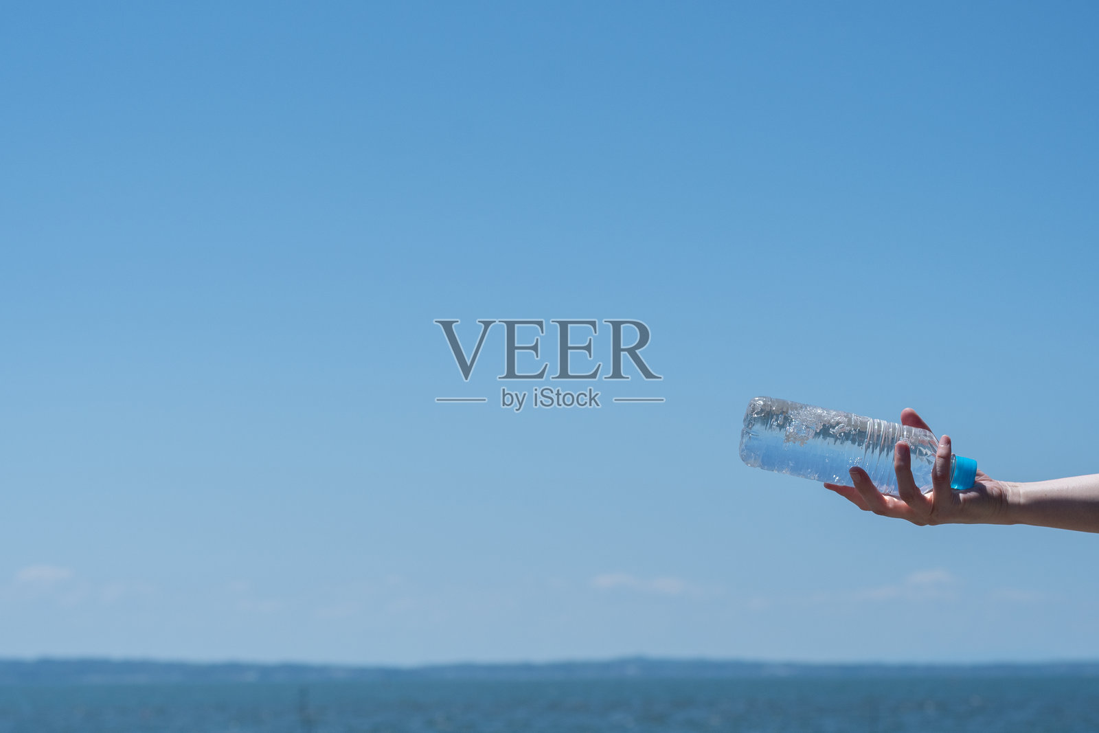 手握塑料水瓶的人照片摄影图片