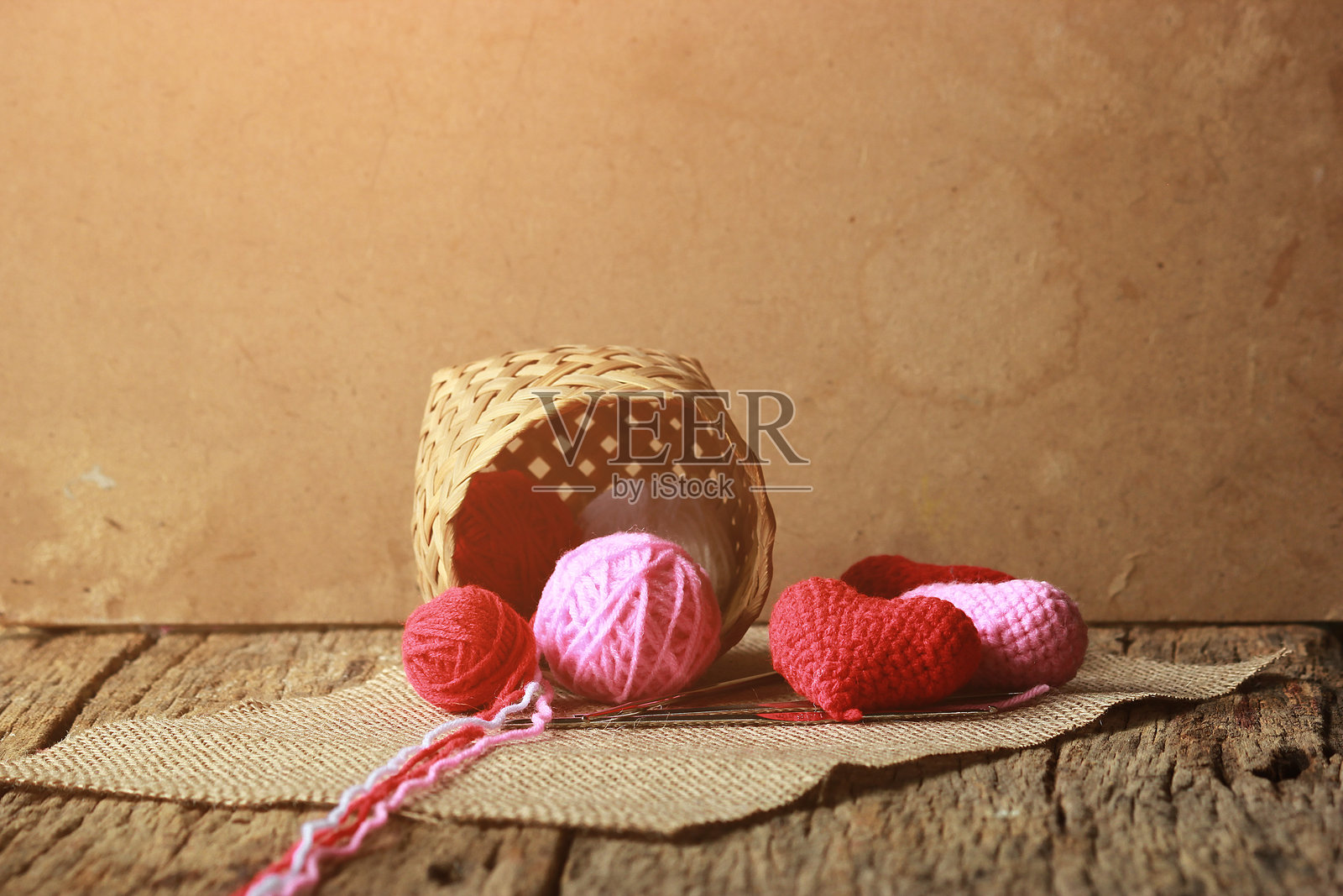 木桌上的篮子里放着毛线球和心形装饰品照片摄影图片