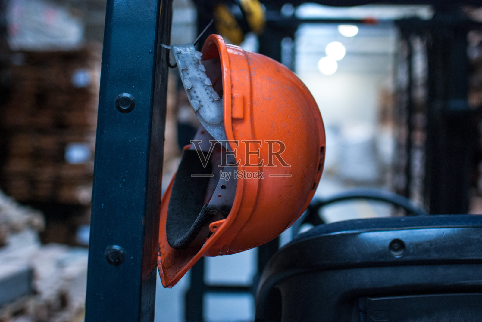 工厂中挂在钩子上的橙色安全帽特写照片摄影图片