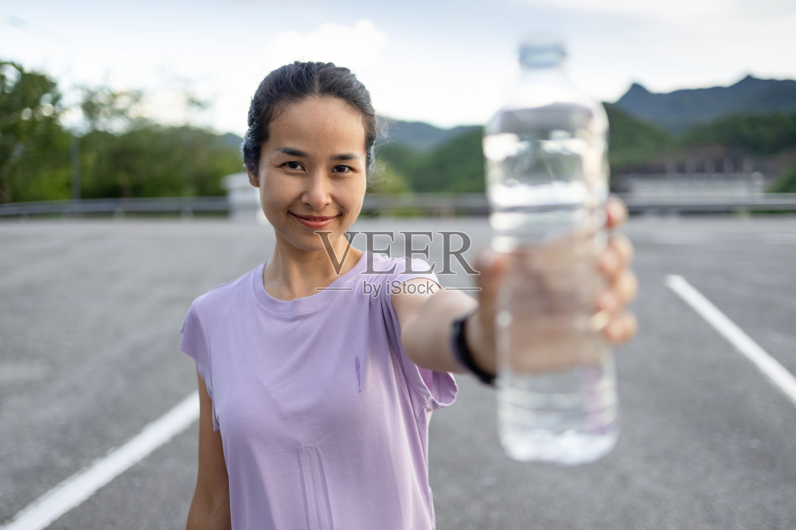 亚洲女性在日落时分锻炼后饮用清水。照片摄影图片
