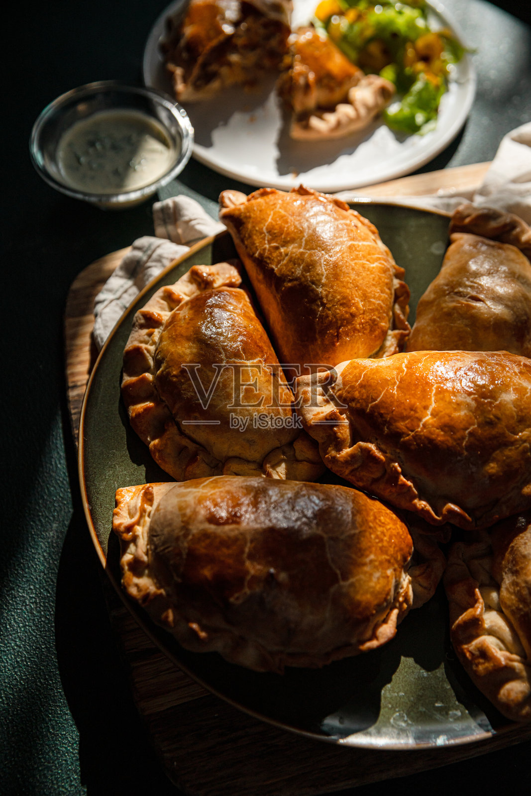 自制的肉菜馅饼放在绿色盘子上。照片摄影图片
