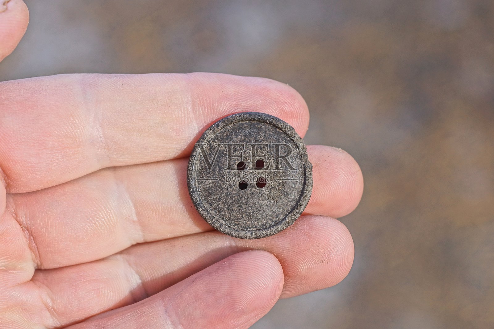 一个大圆形黑色塑料按钮躺在手指上照片摄影图片