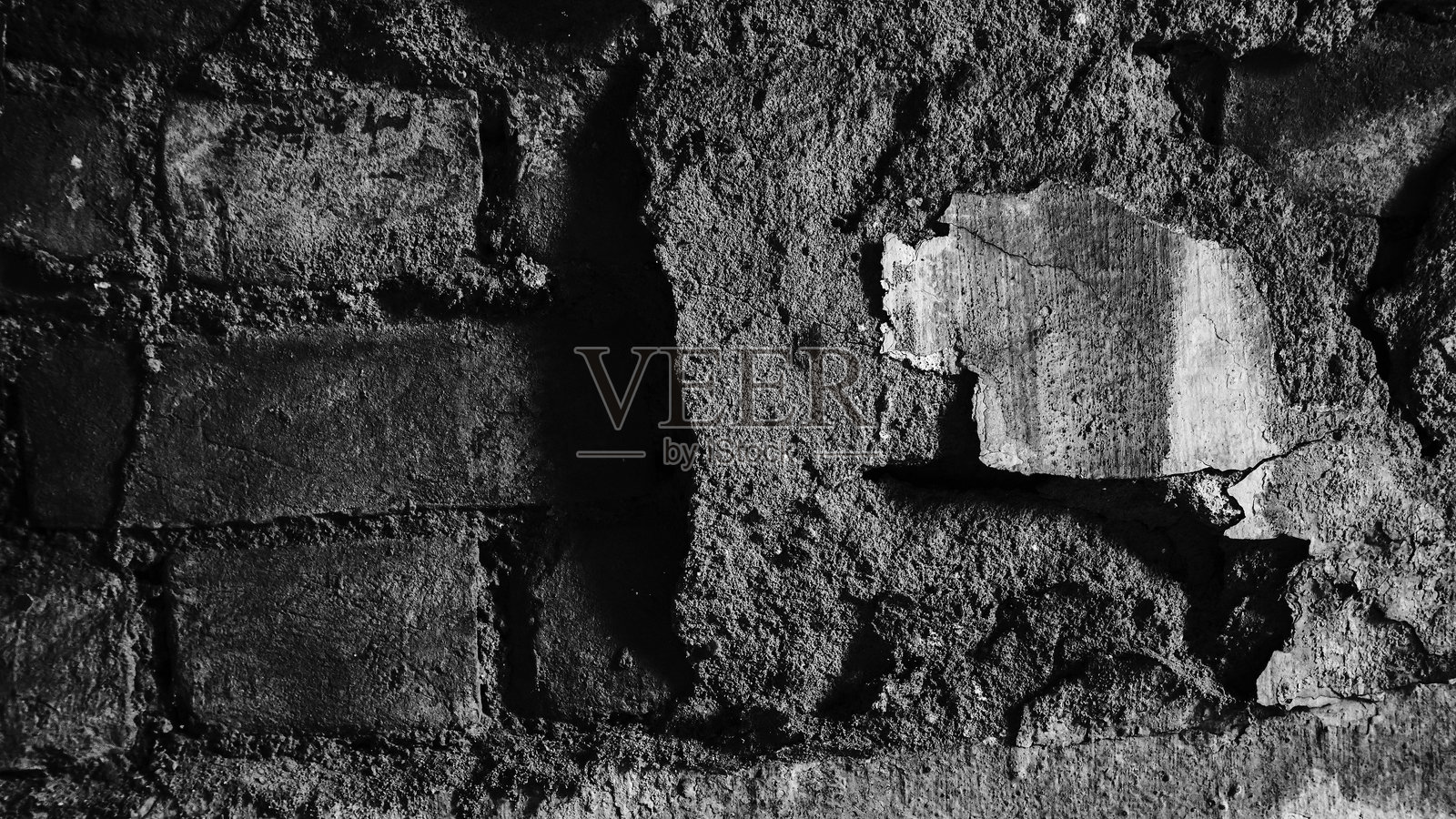 一幅抽象的老墙图像，破损的灰泥下方是部分破碎的旧砖，经历了漫长的岁月。黑白图像展现了老墙的衰老。印度西孟加拉邦霍拉。照片摄影图片