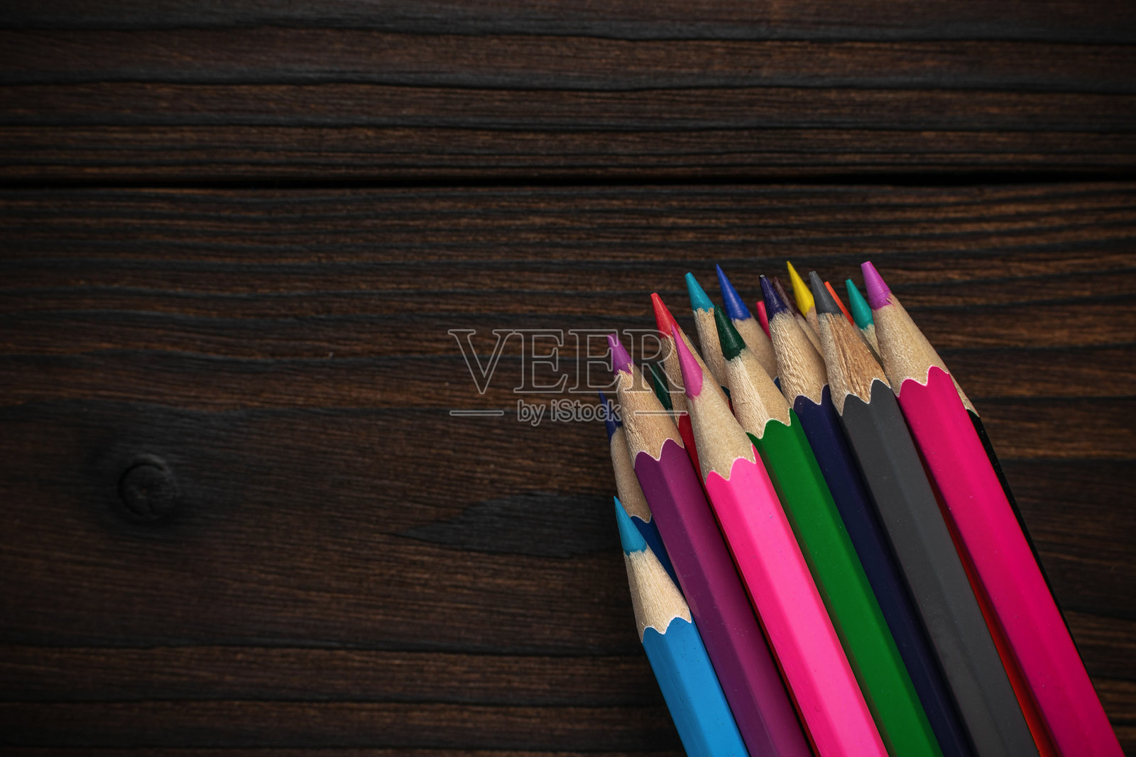 色彩缤纷的铅笔在深色木质背景上 - 充满活力的艺术用品激发创造力照片摄影图片