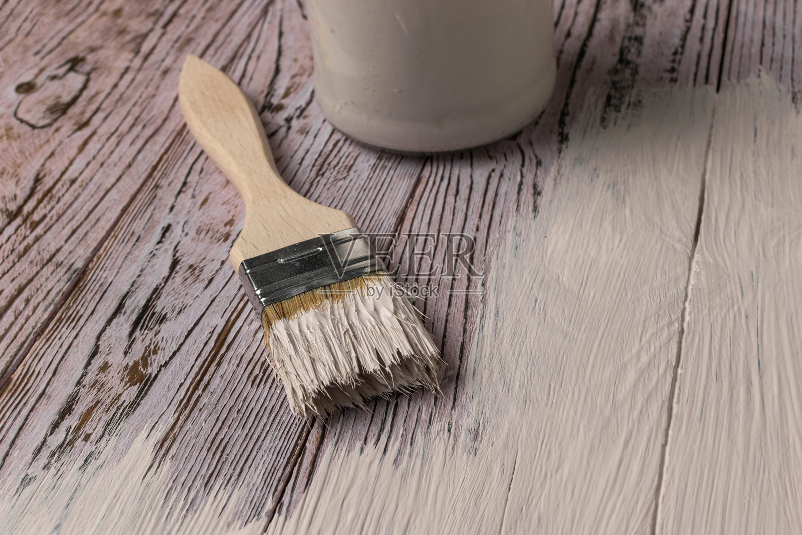 木质表面上的画笔和白色油漆：家居装修和DIY概念照片摄影图片