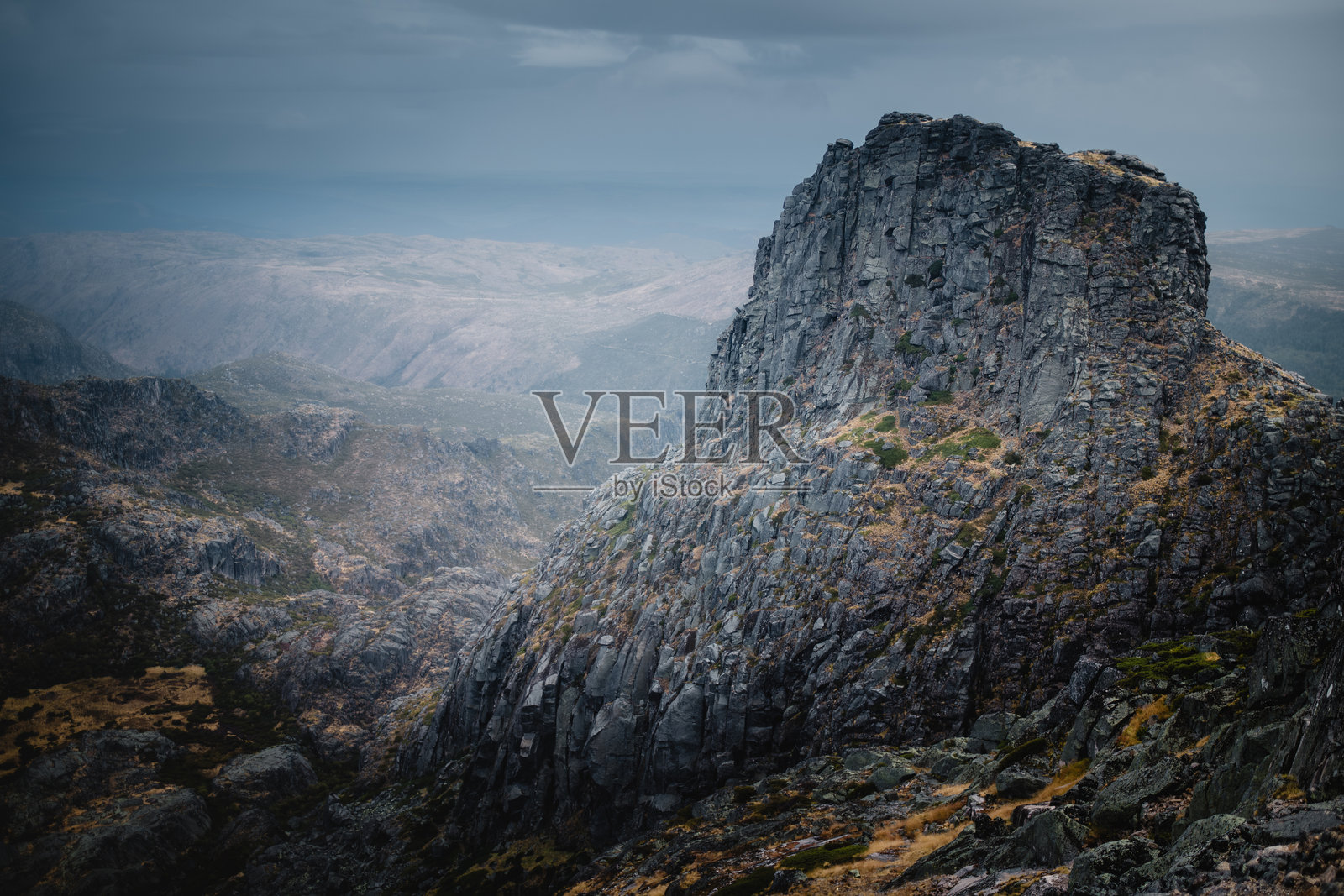 塞拉达埃斯特雷拉的崎岖而美丽的山脉在阴云密布的天空下巍然屹立，岩石的山峰在多云的天气中形成了戏剧性的景象。照片摄影图片