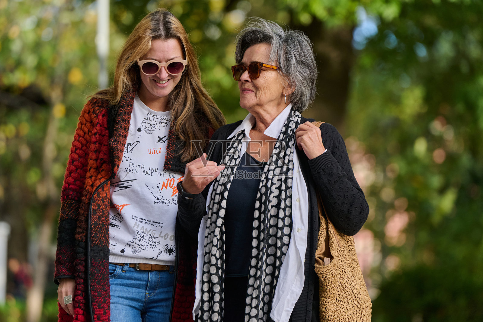 秋天的散步：母女在大自然的怀抱中分享爱与支持。照片摄影图片