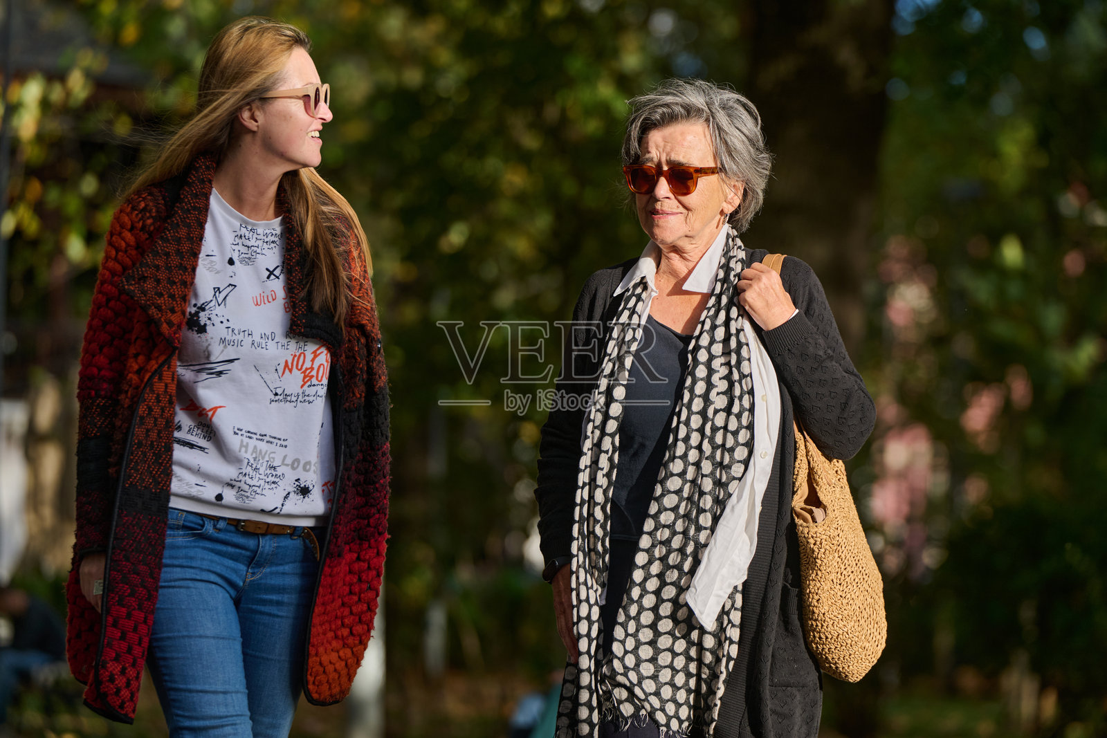 秋日散步：母女在大自然的怀抱中分享爱与支持。照片摄影图片