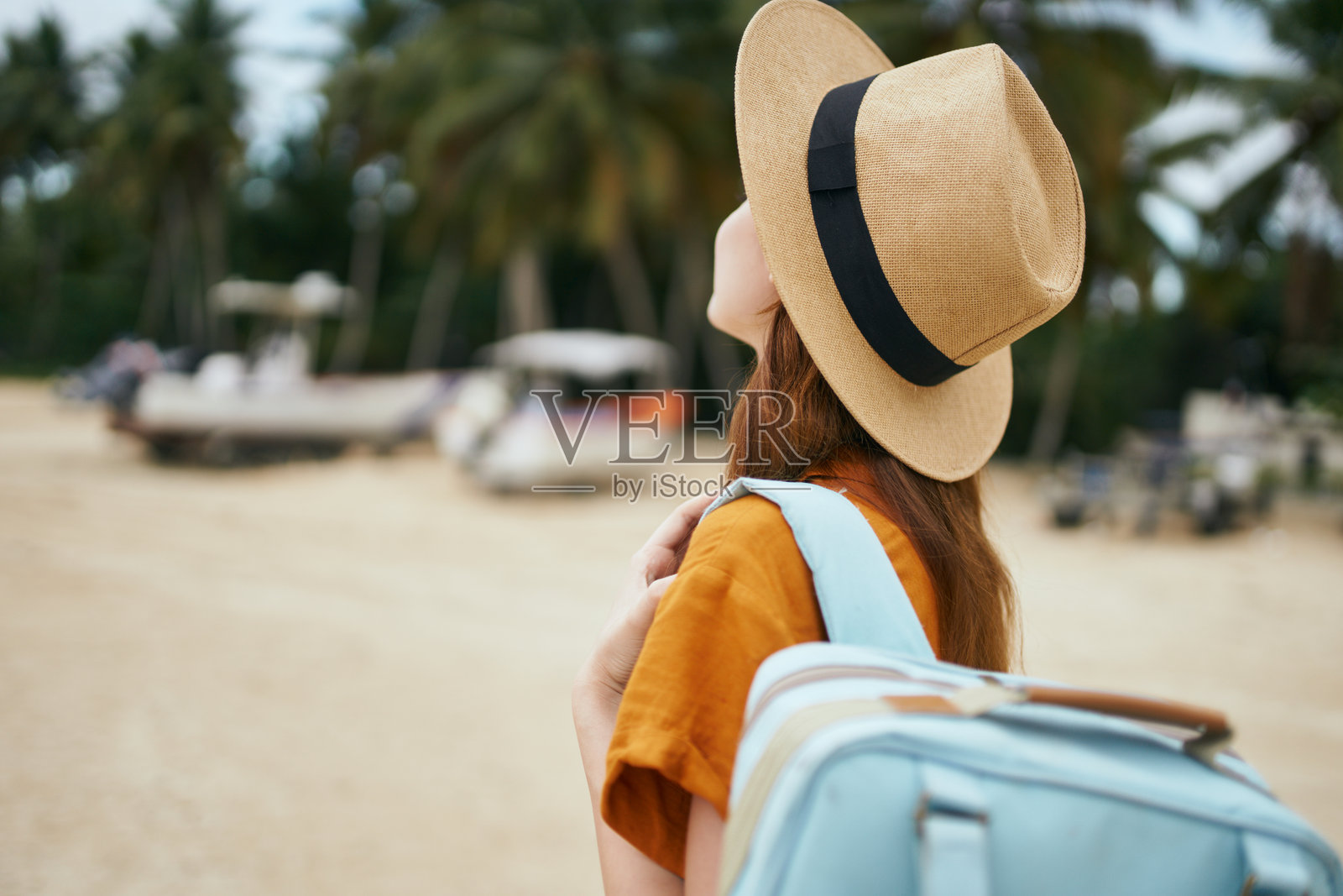 背影的女人戴着帽子站在街上照片摄影图片