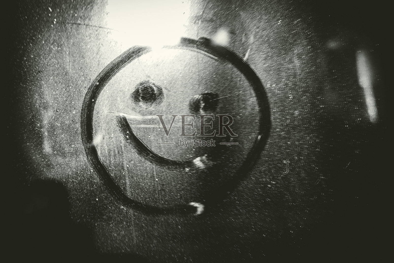 用手指在尘土覆盖的玻璃上画一个微笑图标照片摄影图片