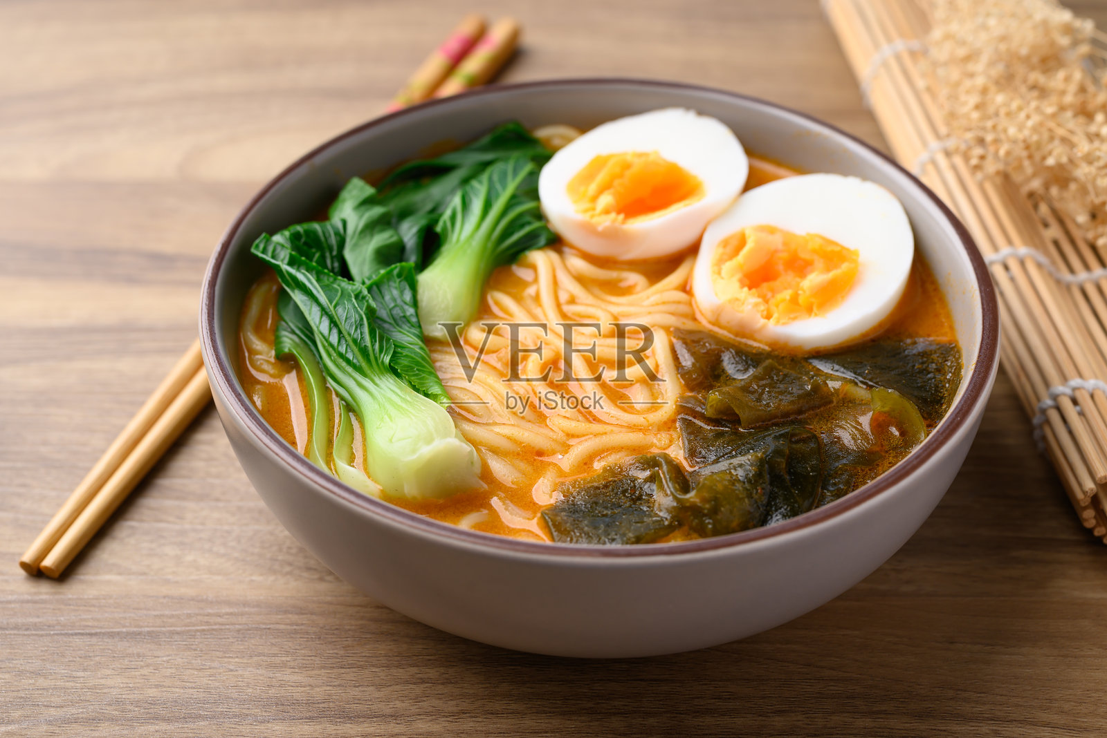 碗里盛着辣味面条汤，配有鸡蛋、海带和小白菜，亚洲面条风格照片摄影图片