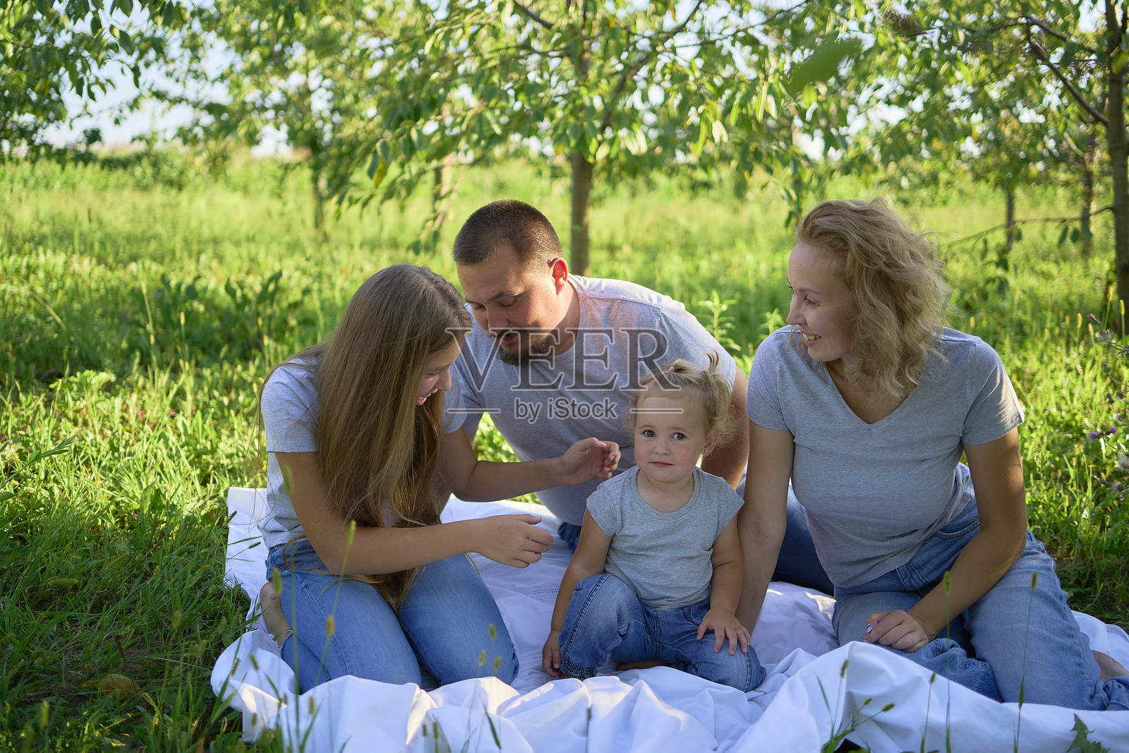 一家四口在公园野餐照片摄影图片